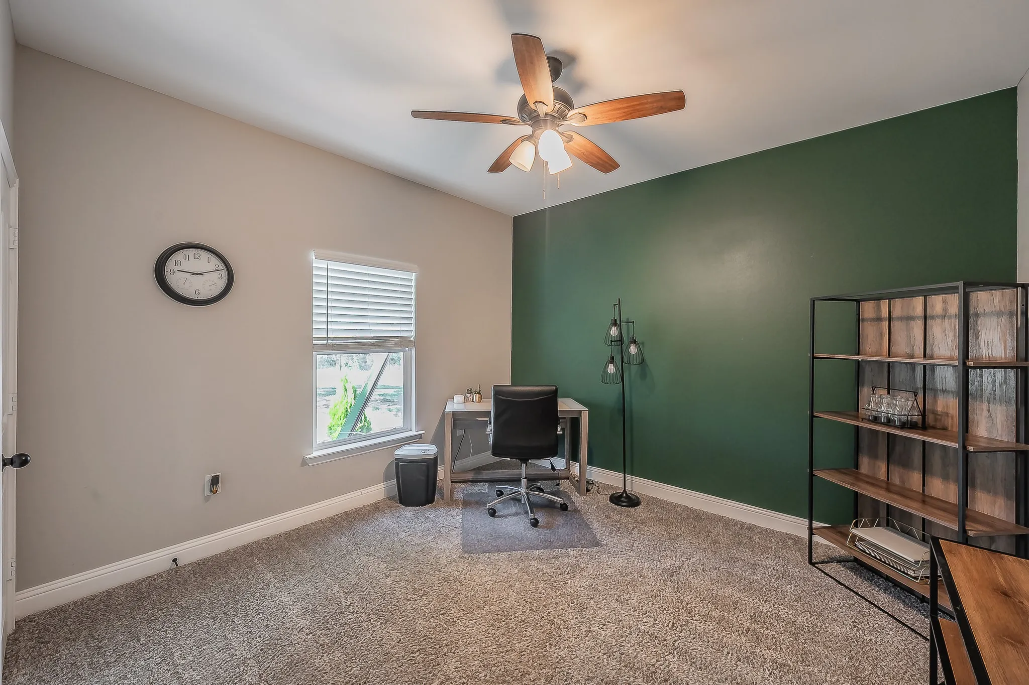 Vaulted ceiling with a wood-finish ceiling fan, a window with blinds, and a built-in shelving unit with wood-finish shelves and a black metal frame