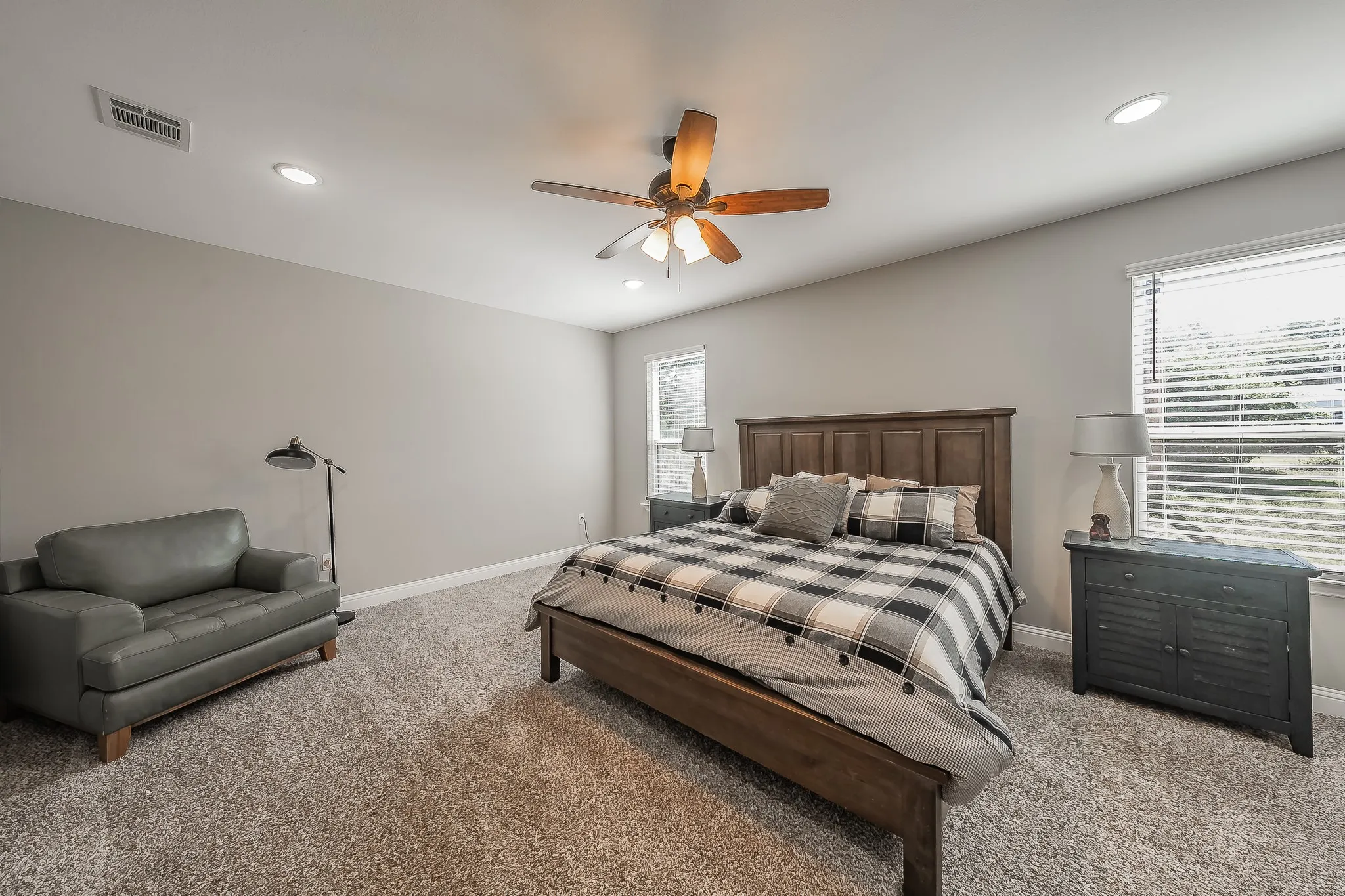 Bedroom featuring neutral-toned walls, plush carpet flooring, recessed lighting, and a ceiling fan with integrated lighting