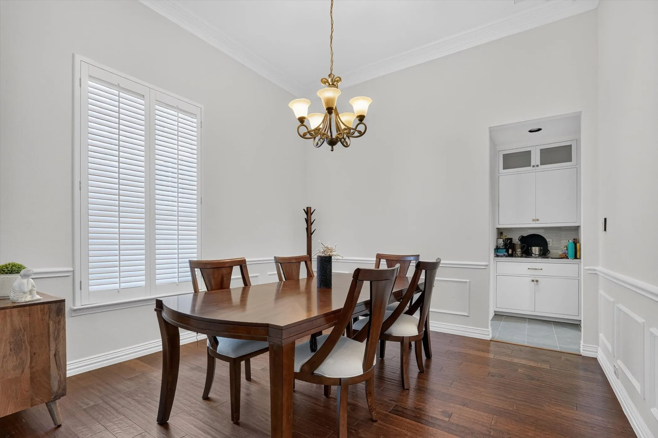 Dining area featuring wood-finish flooring and wainscoting
