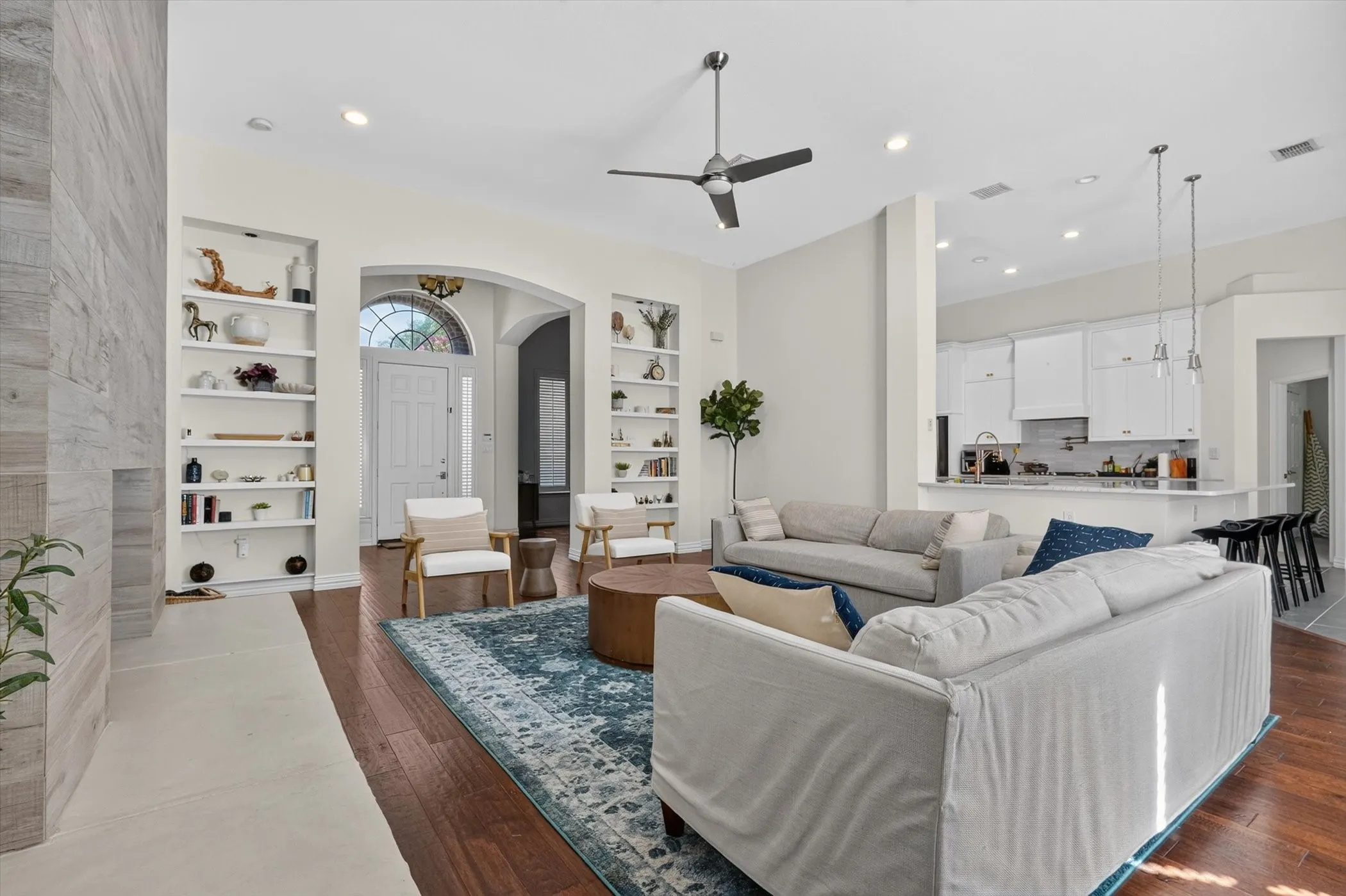 Bright living area featuring wood-finish flooring, a contemporary ceiling fan, and recessed lighting