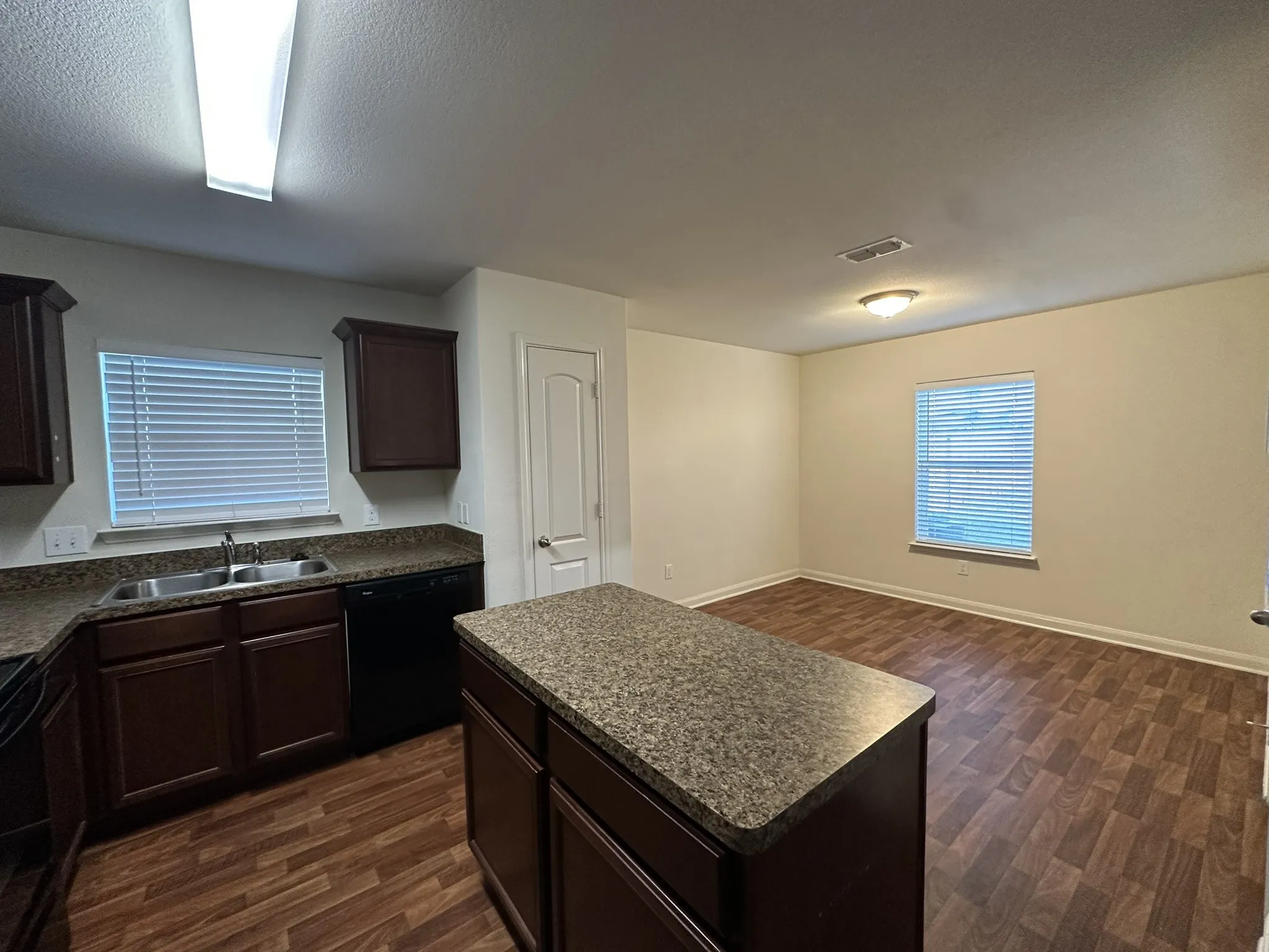 Kitchen featuring dark wood cabinetry, a central island, and wood-finish flooring