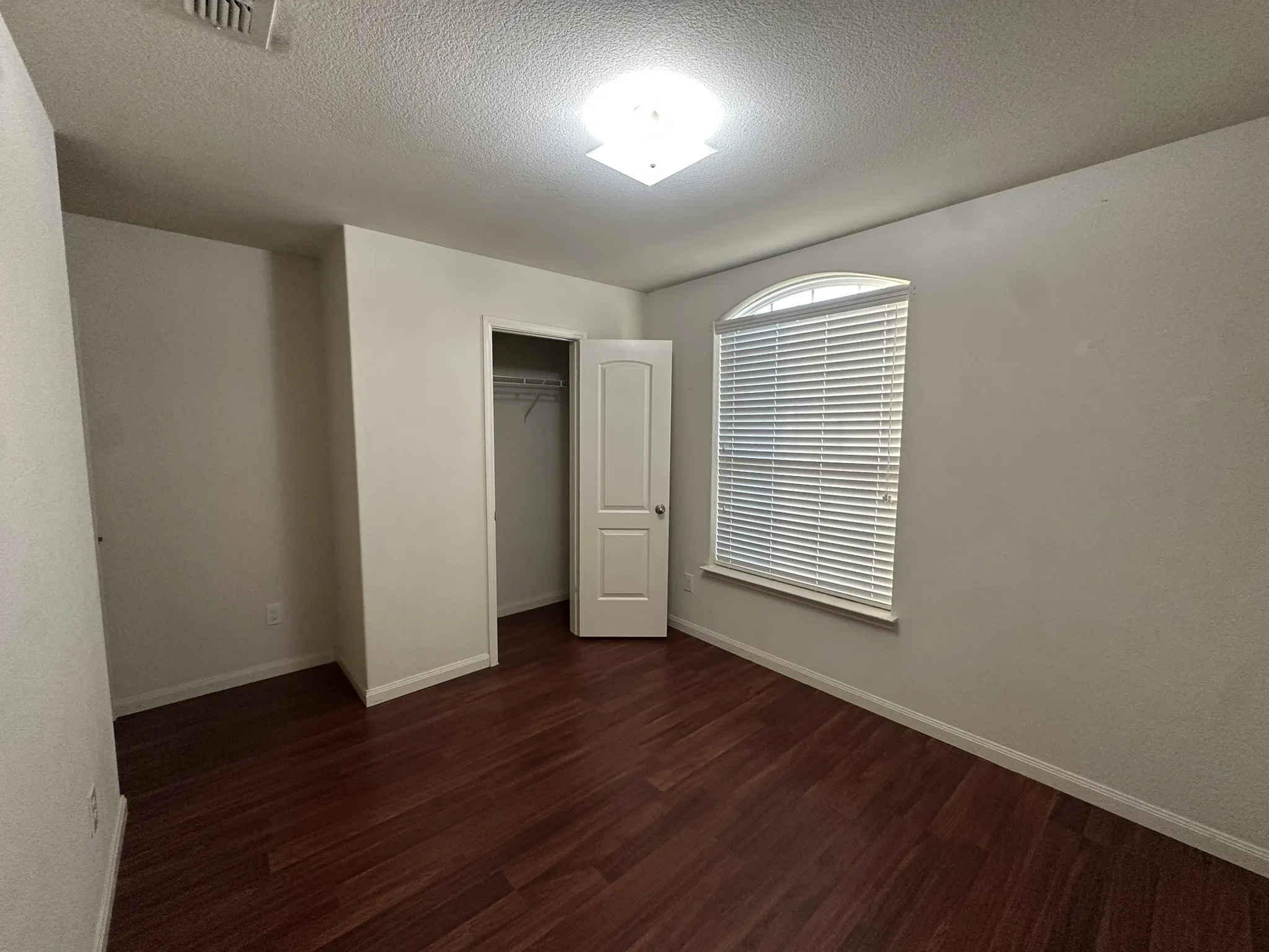 Room with rich wood-finish flooring and light-toned walls