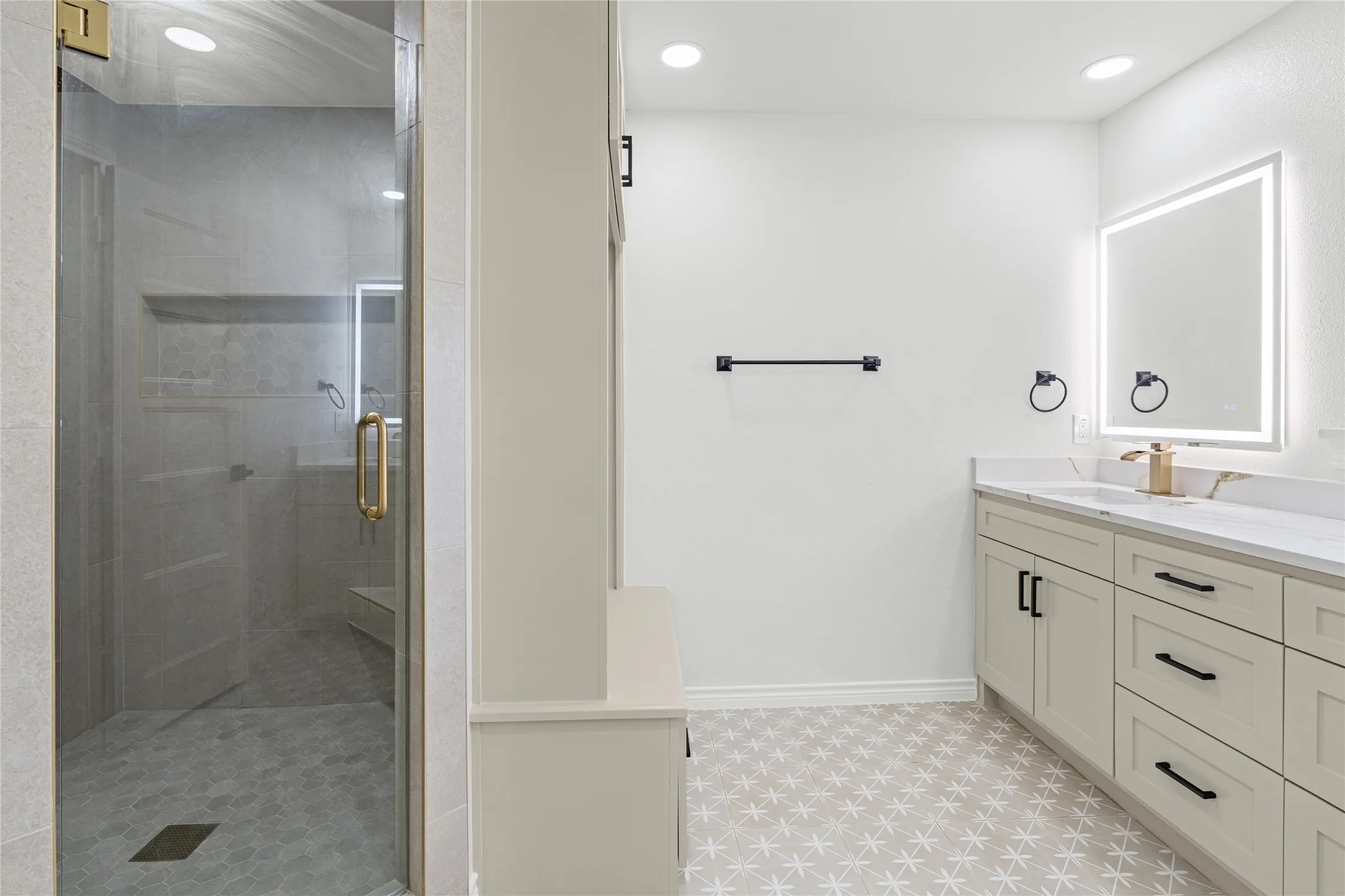 Walk-in shower with clear glass enclosure and gold-toned hardware