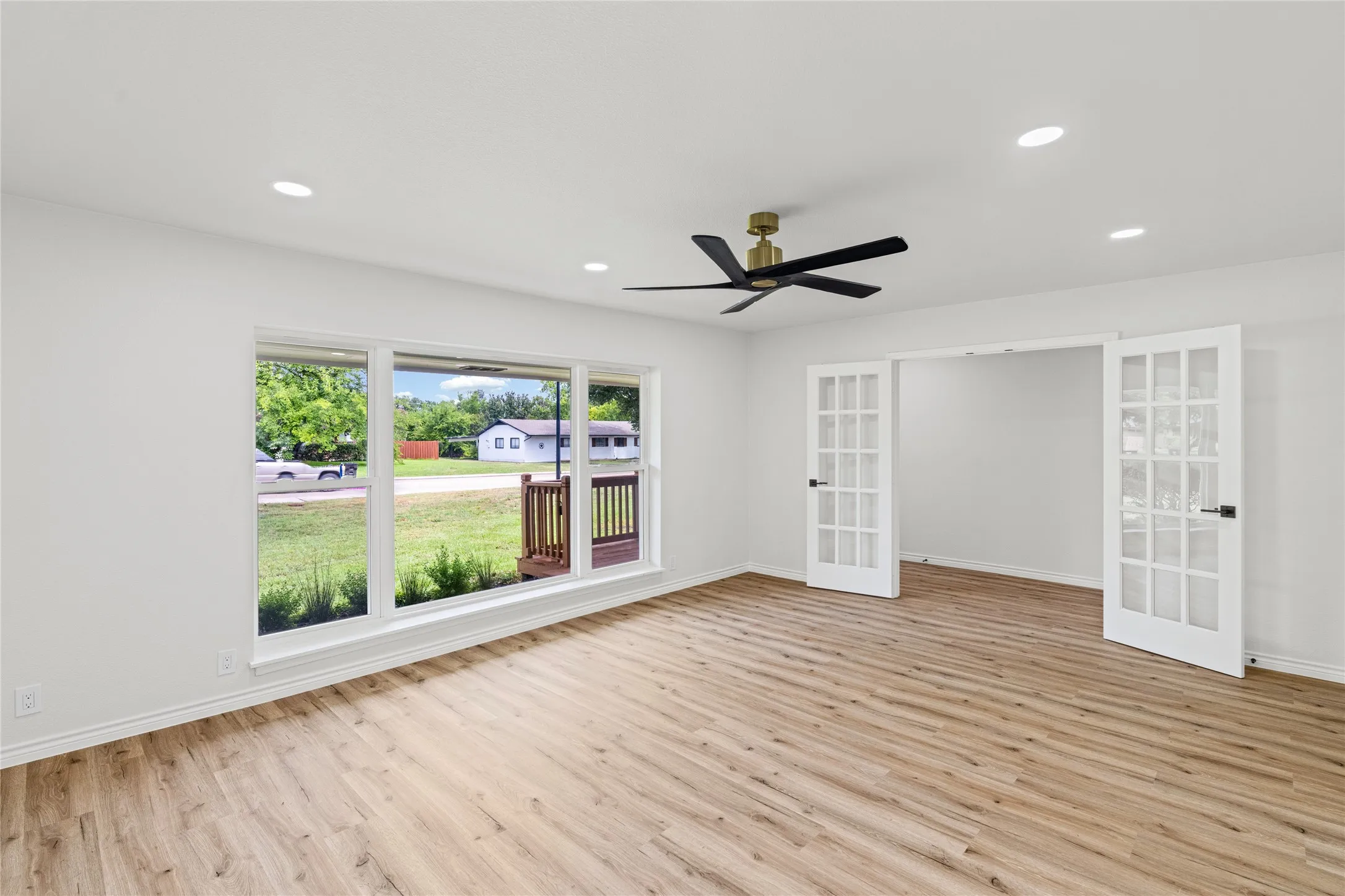 Bright interior space featuring wood-finish flooring, recessed lighting, and a contemporary ceiling fan