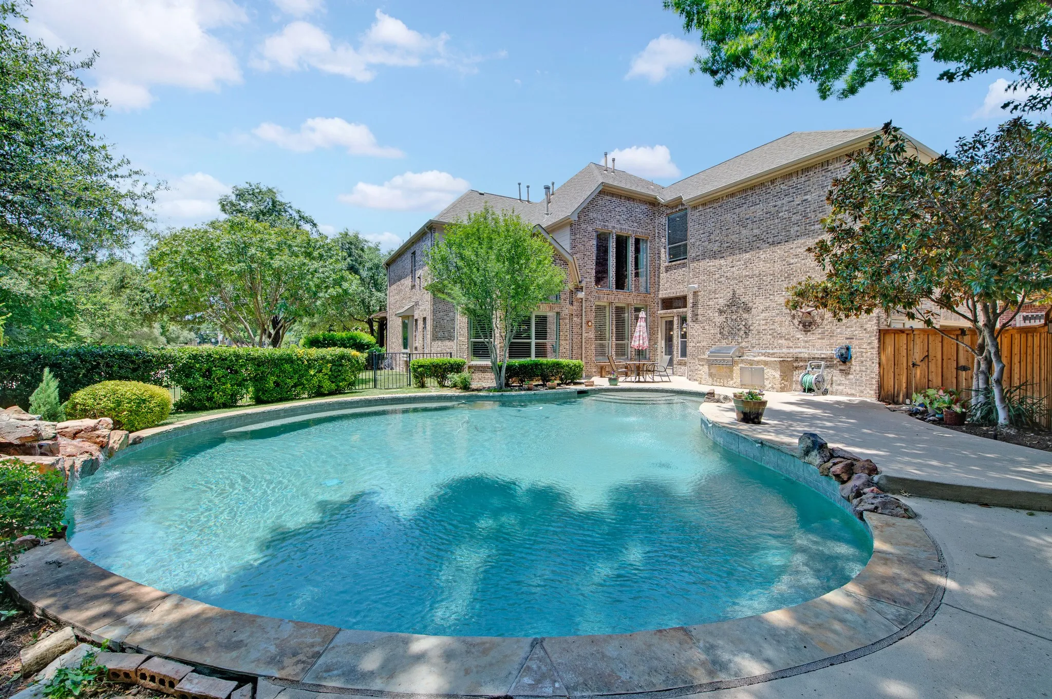 With an outdoor gas grill and pergola