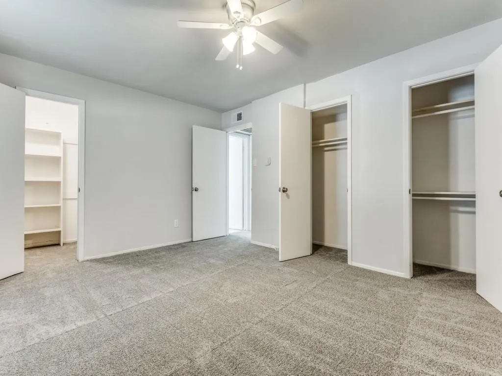 Spacious room featuring light gray carpeting and white walls