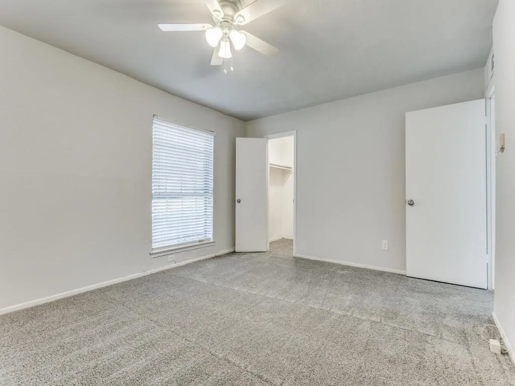 Spacious room featuring neutral carpeting and light-colored walls