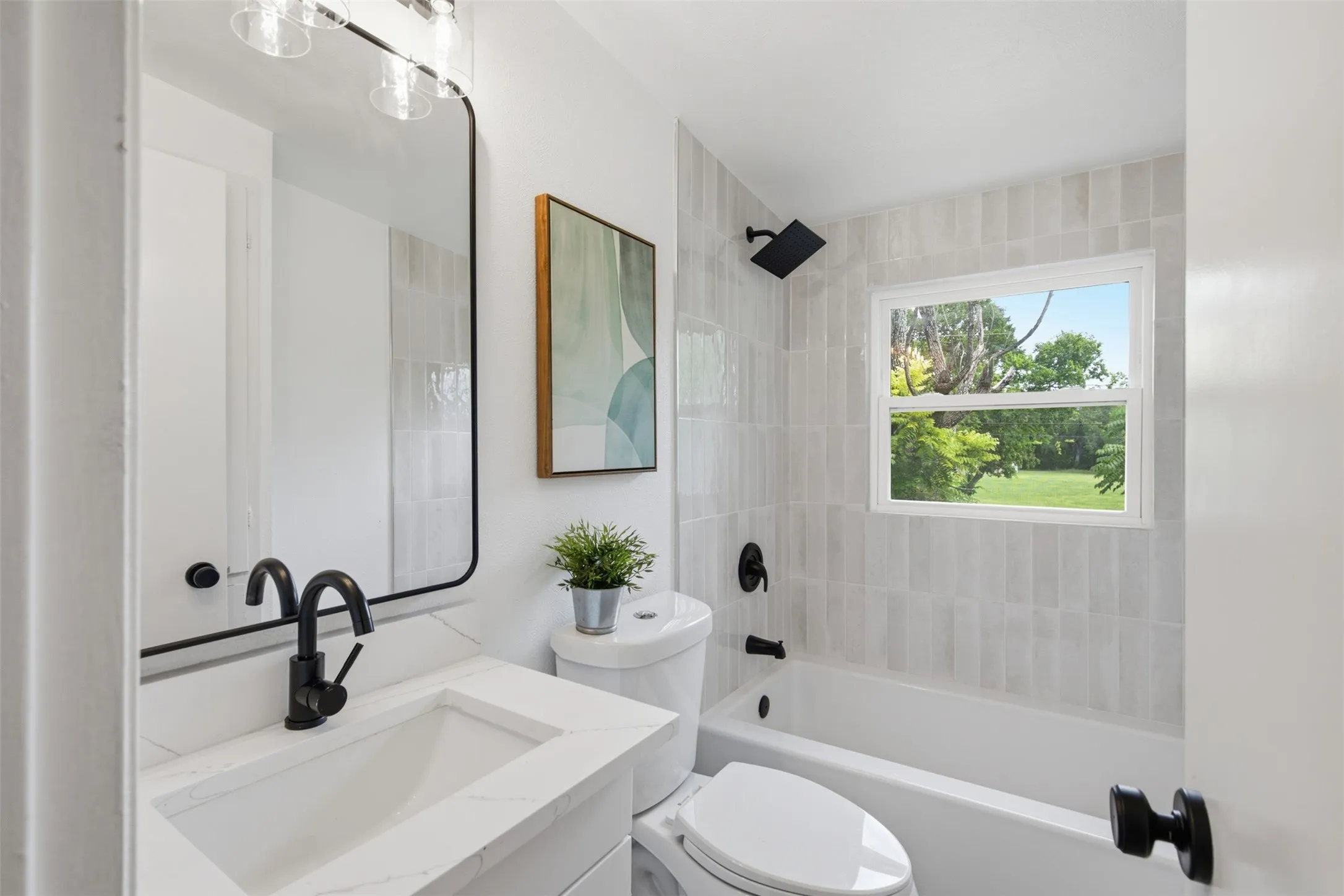 Remodeled Upstairs Bath — Updated tile, a tub-and-shower combination, a quartz-style vanity, and matte black fixtures create a fresh, cohesive bath serving the two upper-level bedrooms.