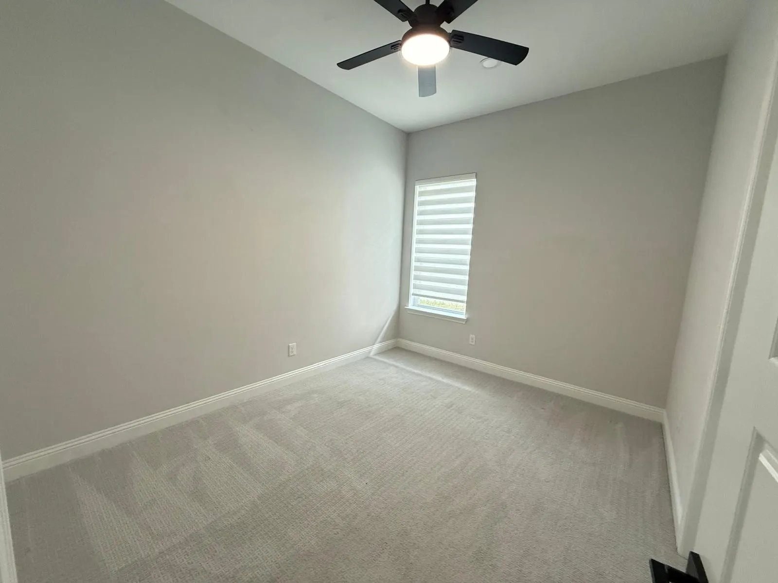Bedroom featuring neutral wall color, light-toned carpeting, a window with horizontal blinds, and a ceiling fan with integrated lighting