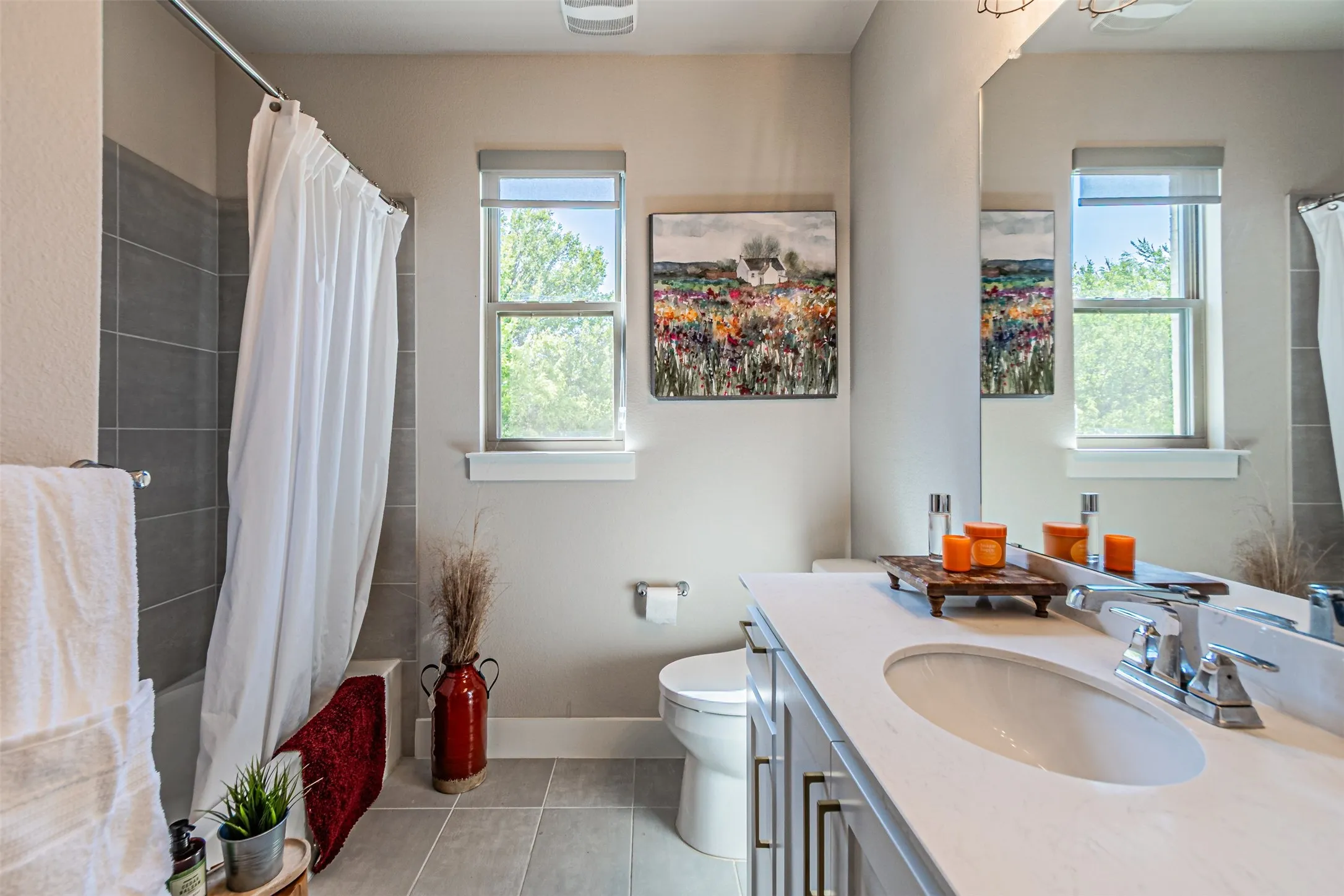 Bathroom featuring a single vanity with an integrated sink, polished chrome faucet, and a large wall-mounted mirror