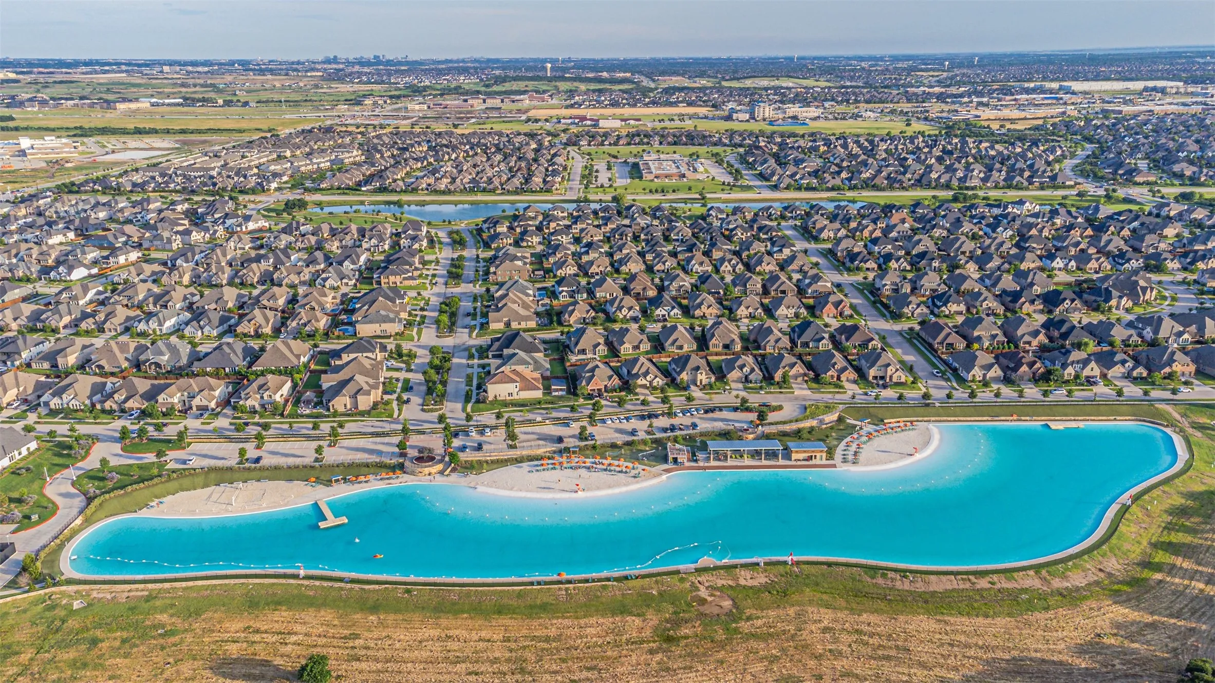 Expansive neighborhood featuring numerous residential properties and a large, blue-water lagoon