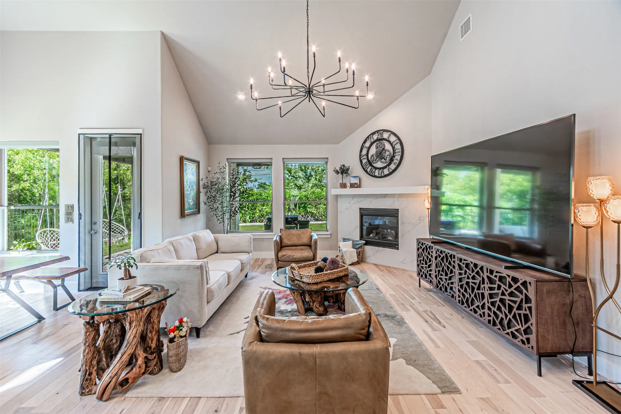 Vaulted ceiling living area featuring light wood-finish flooring