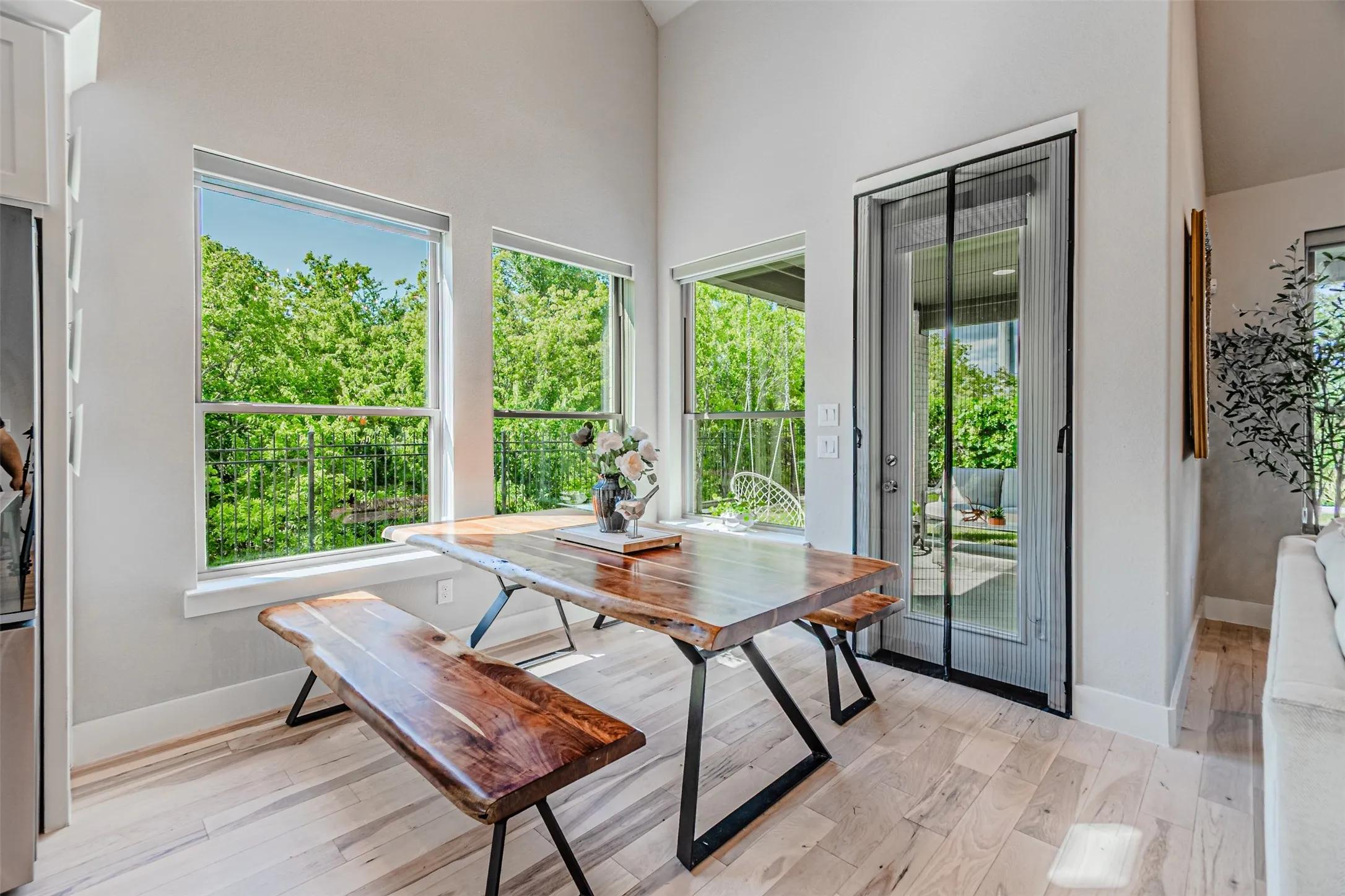 Light wood-finish flooring enhances this dining area, featuring a full-light glass door providing exterior access