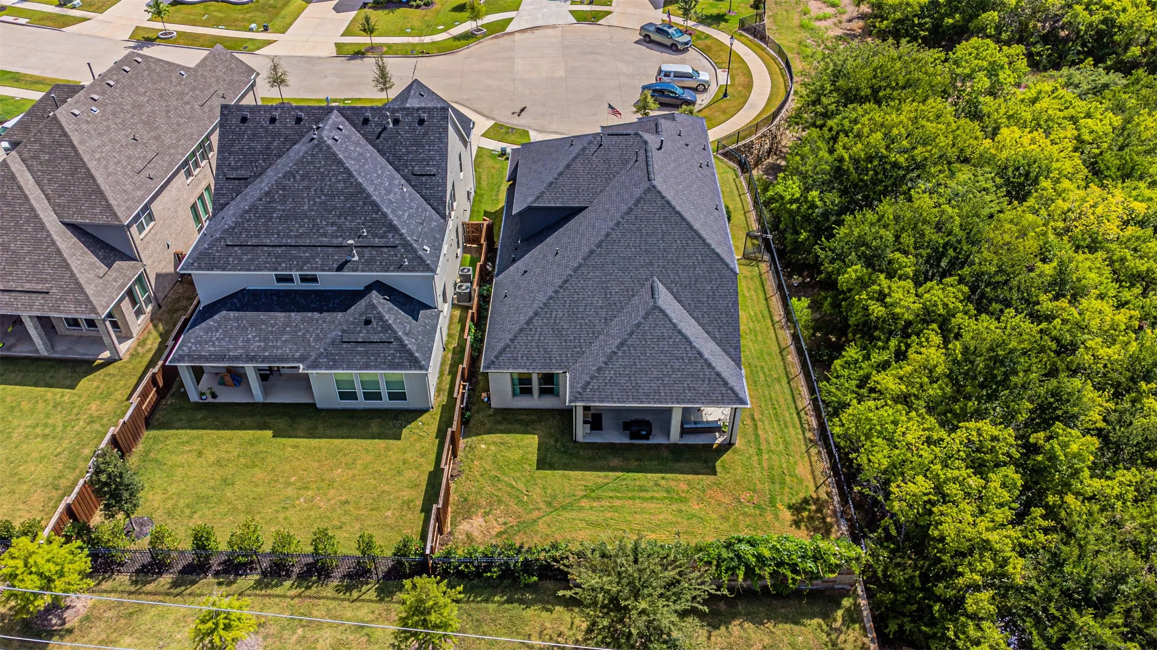 Expansive residential property featuring a dark shingle roof and a spacious green lawn