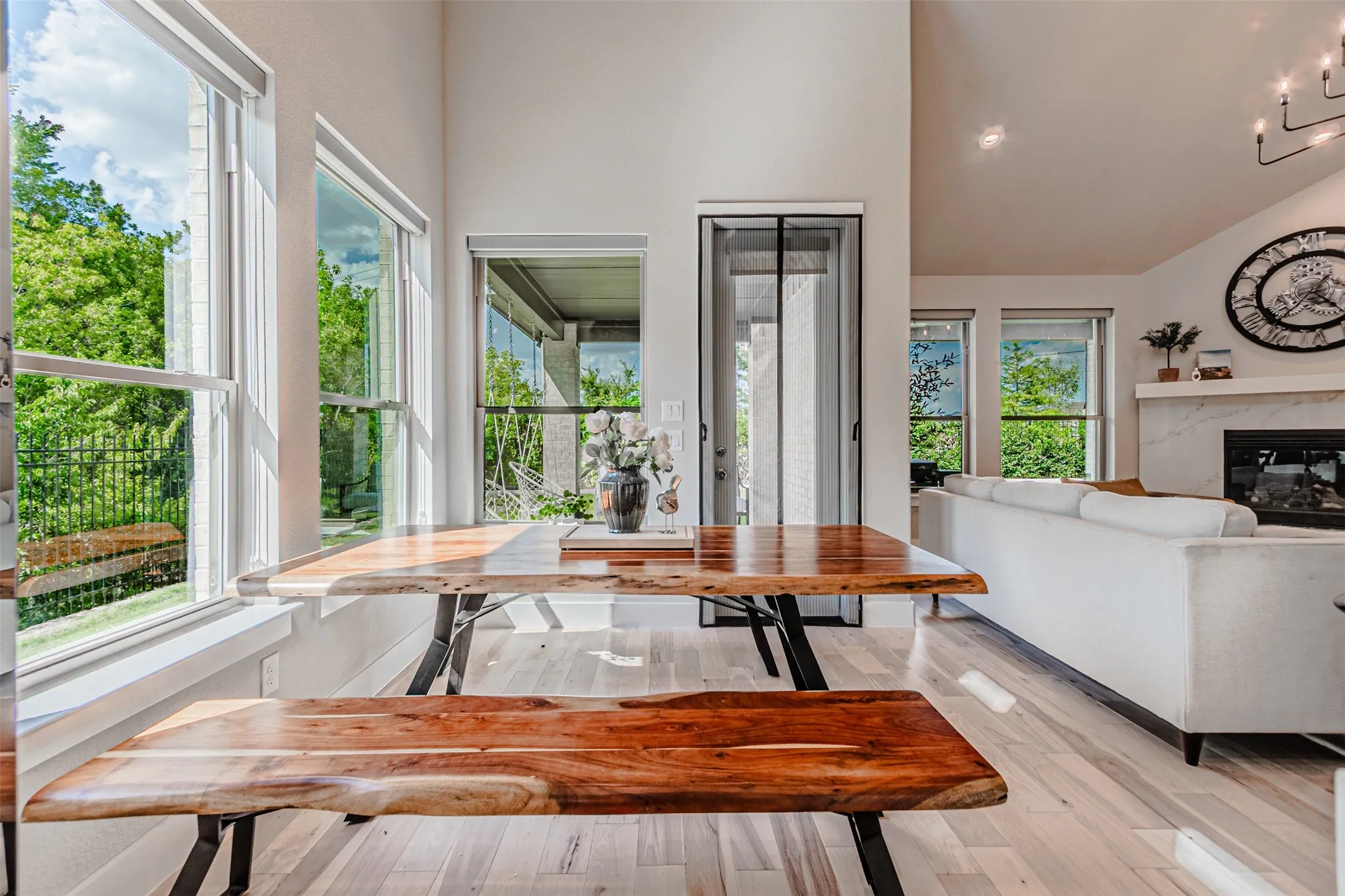 Open-concept interior featuring light wood-finish flooring and multiple large windows