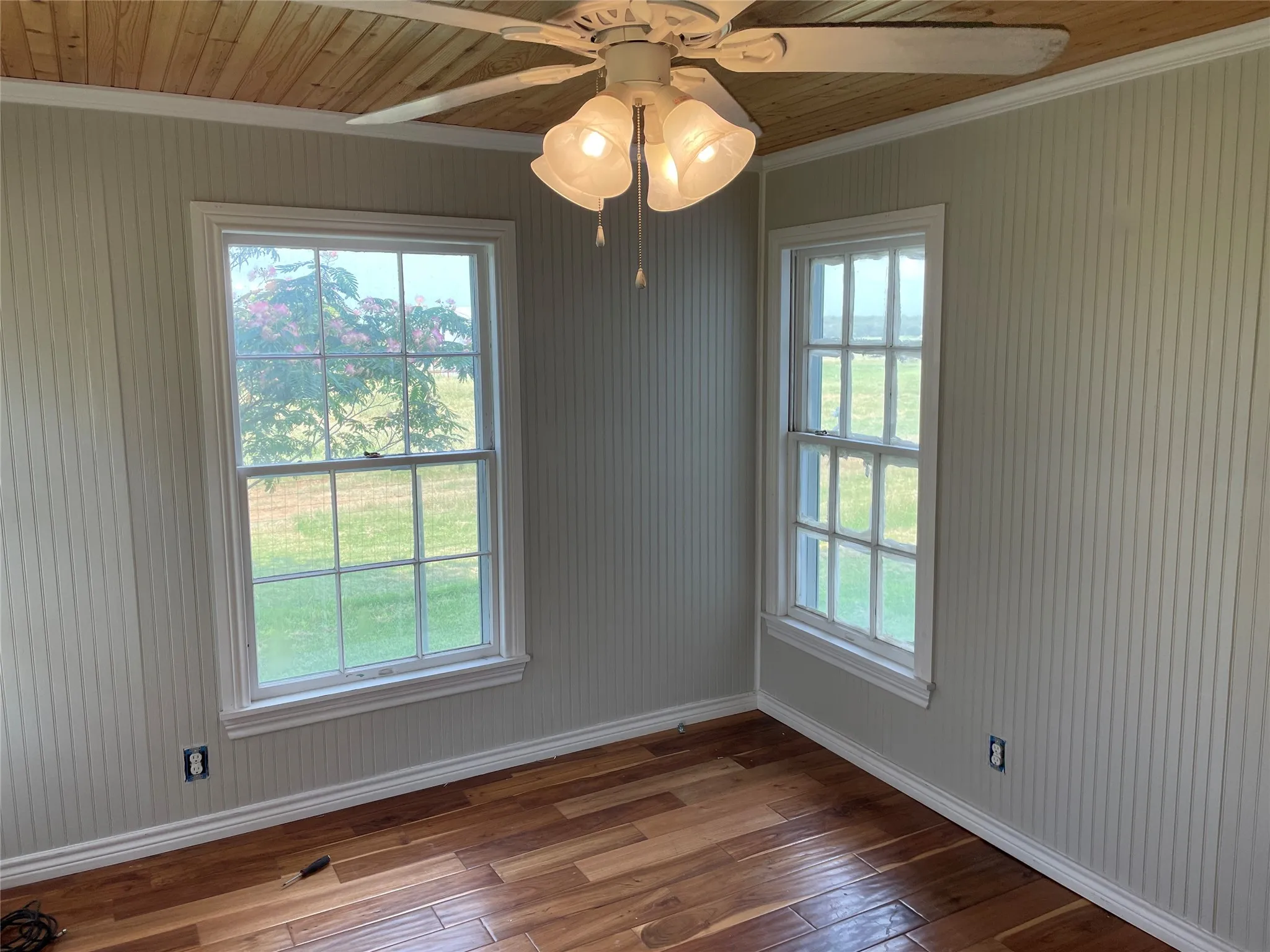 Interior room featuring wood-finish flooring, vertical slat wall paneling, and a wood plank ceiling