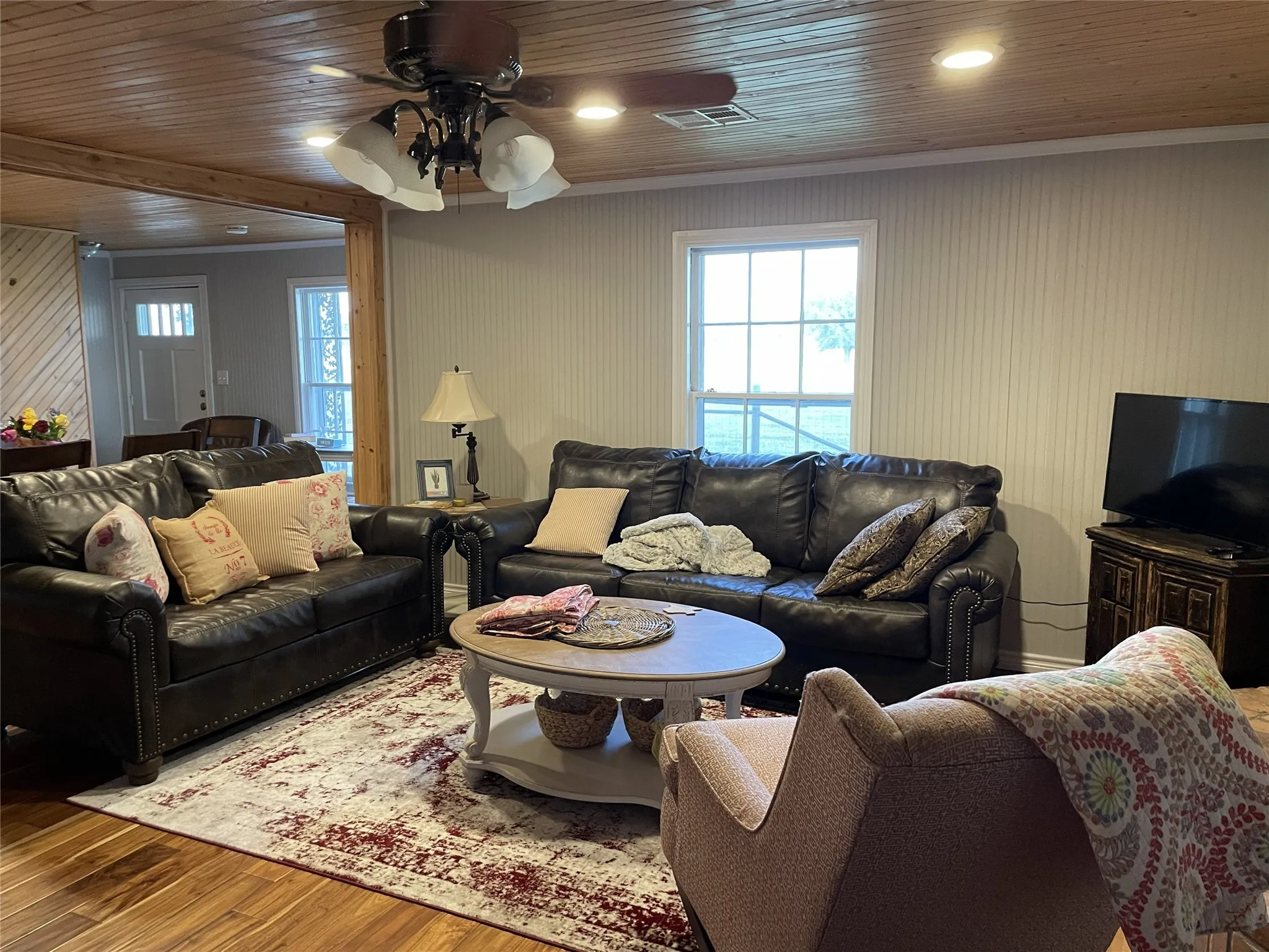 Living area featuring wood-finish flooring, a planked wood ceiling, and recessed lighting