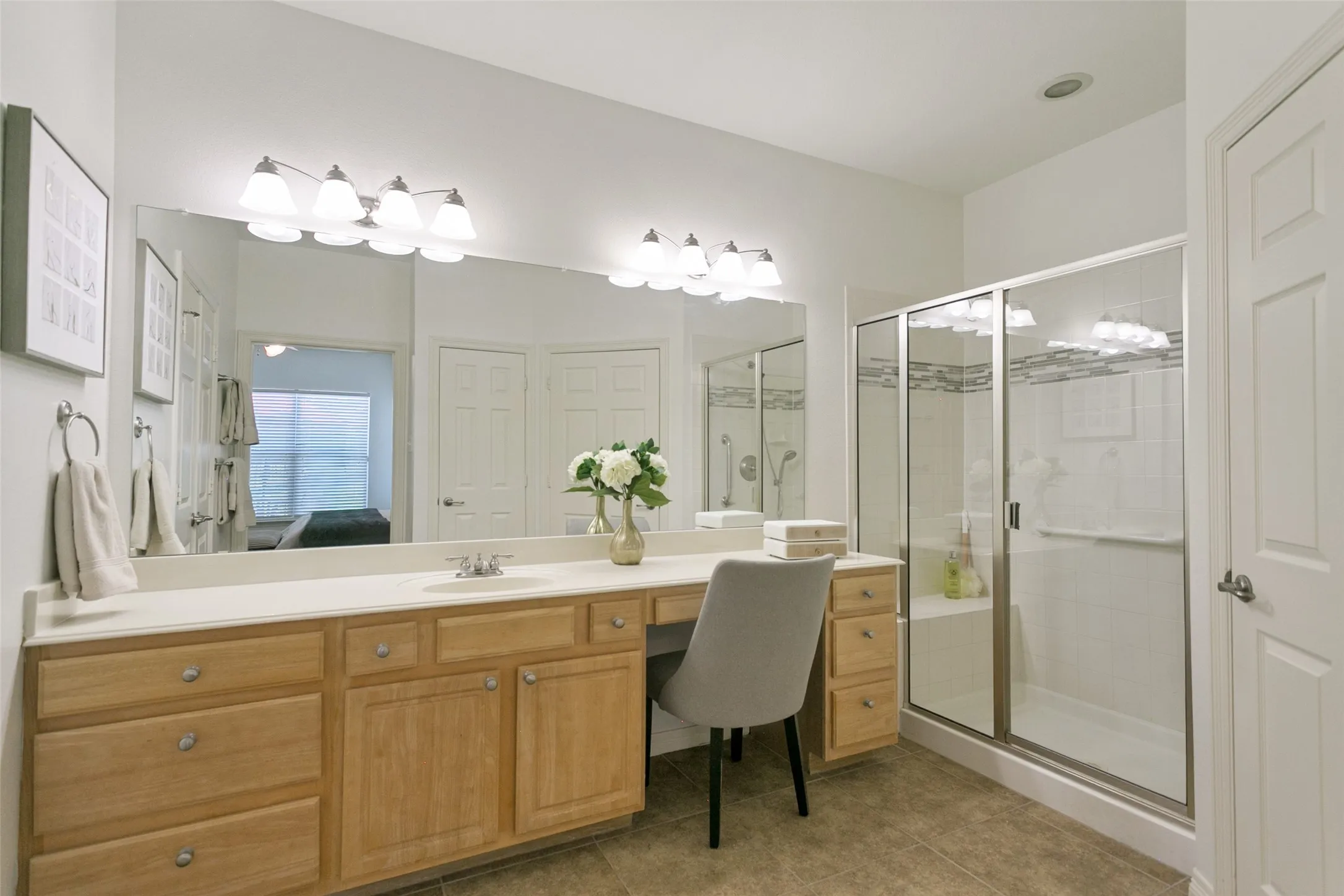 Another view of the spacious primary bathroom featuring a walk-in accessible shower and a private water closet.
