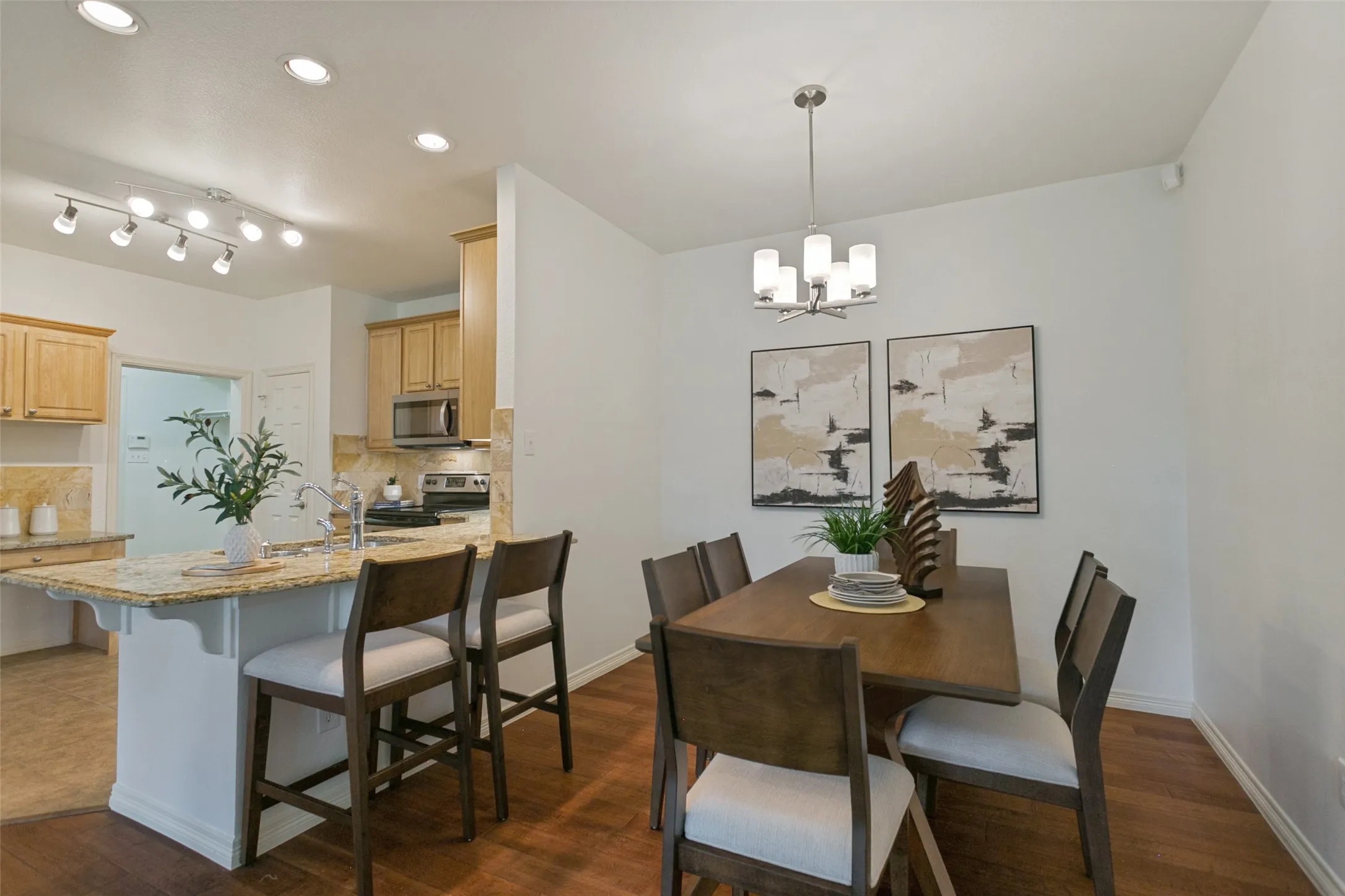 Generously sized dining room with ample space for a china cabinet or hutch, complemented by additional seating at the kitchen countertop. The counter-height design creates an inviting, accessible space perfect for casual meals and everyday convenience.