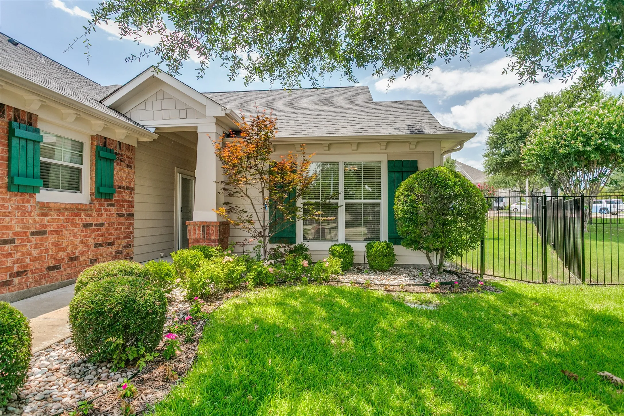 Another view showcasing the inviting covered entryway and beautifully landscaped front yard.