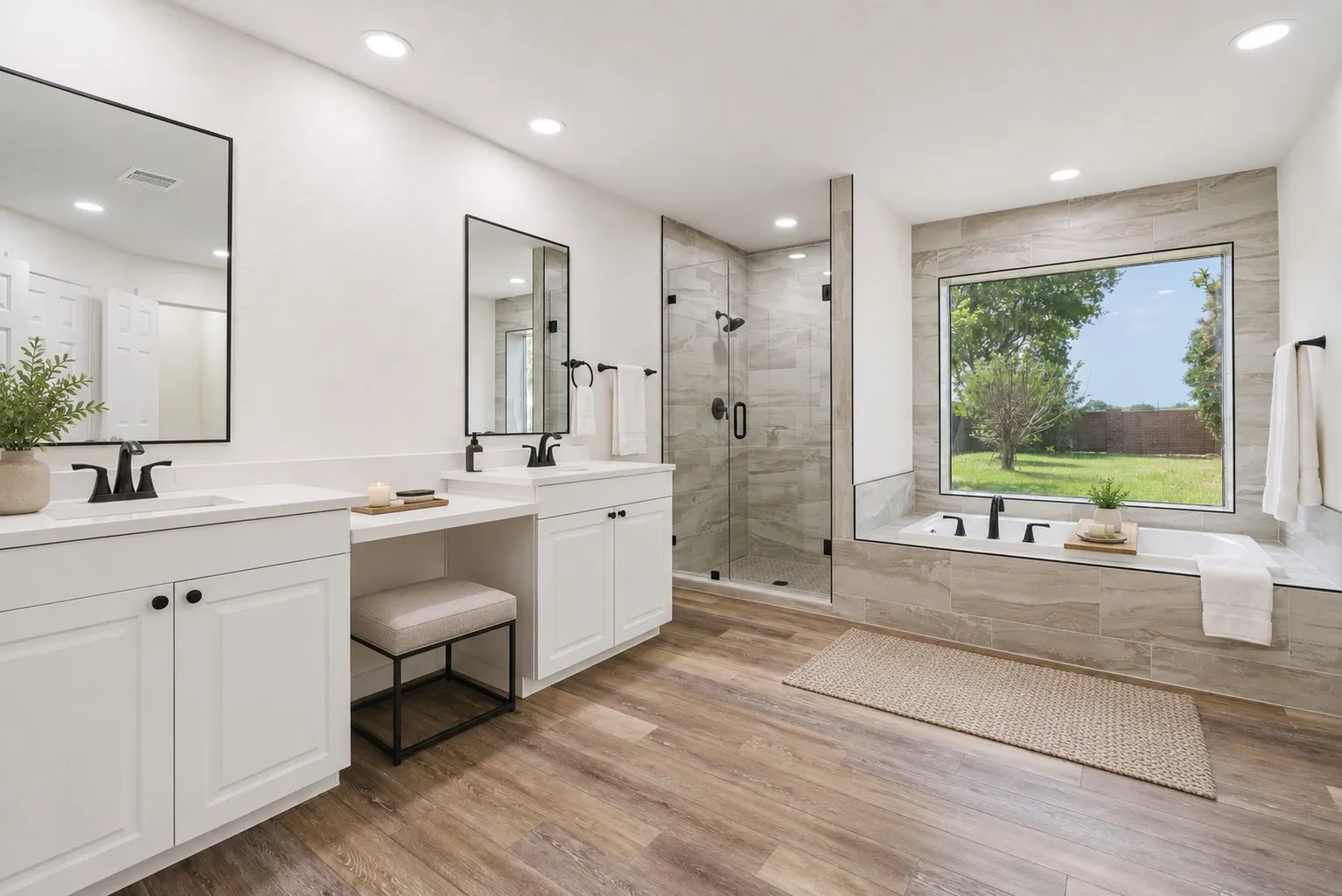 Spa-inspired primary bath with dual vanities, soaking tub, and separate shower.