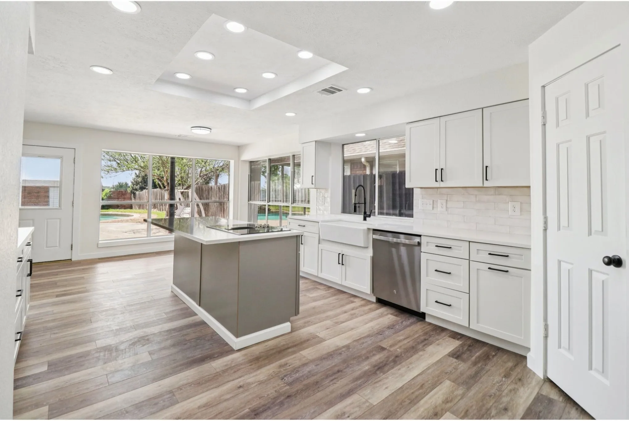 Open kitchen with abundant cabinetry, stainless appliances, and island seating.