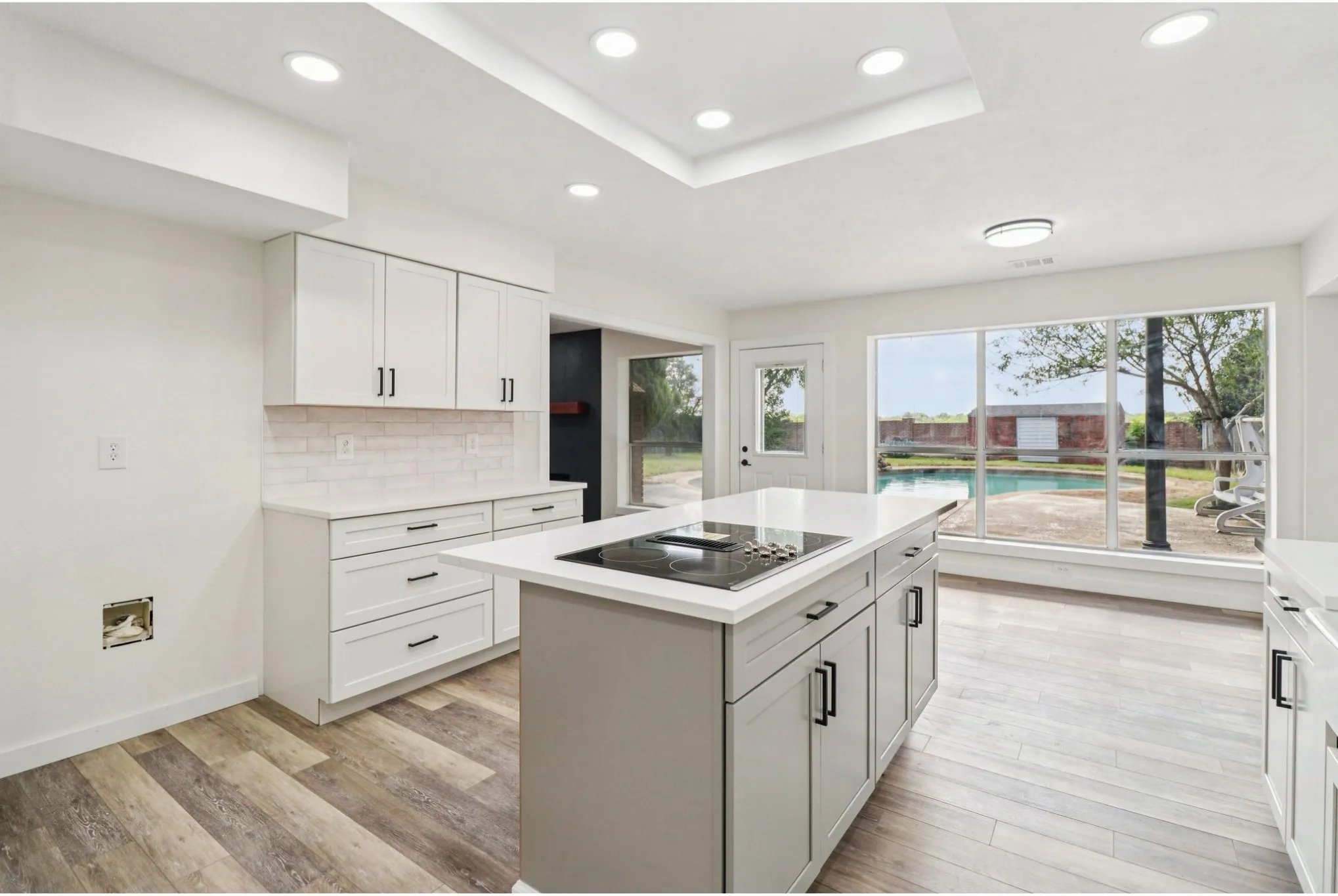 Open kitchen with abundant cabinetry, stainless appliances, and island seating.
