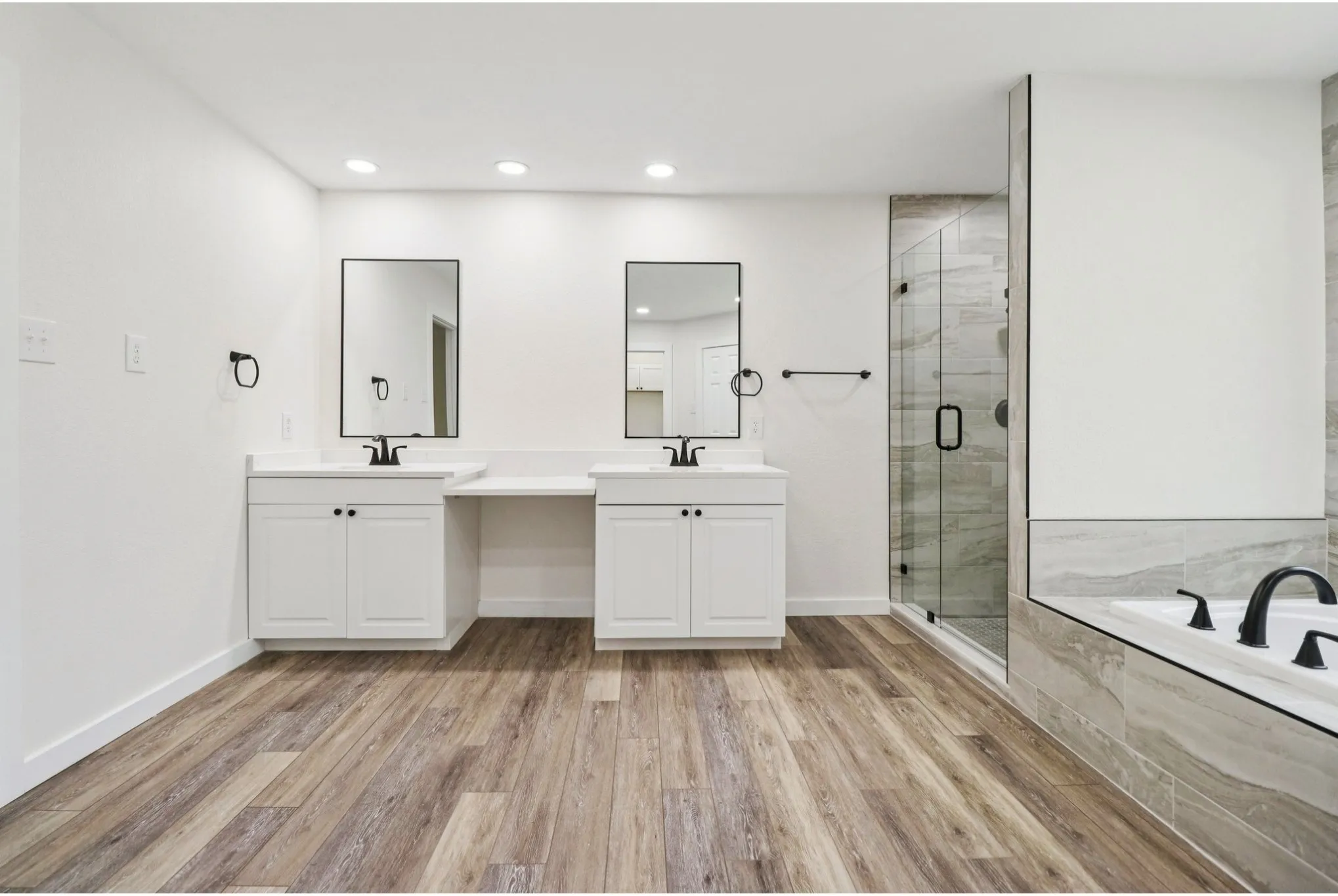 Spa-inspired primary bath with dual vanities, soaking tub, and separate shower.