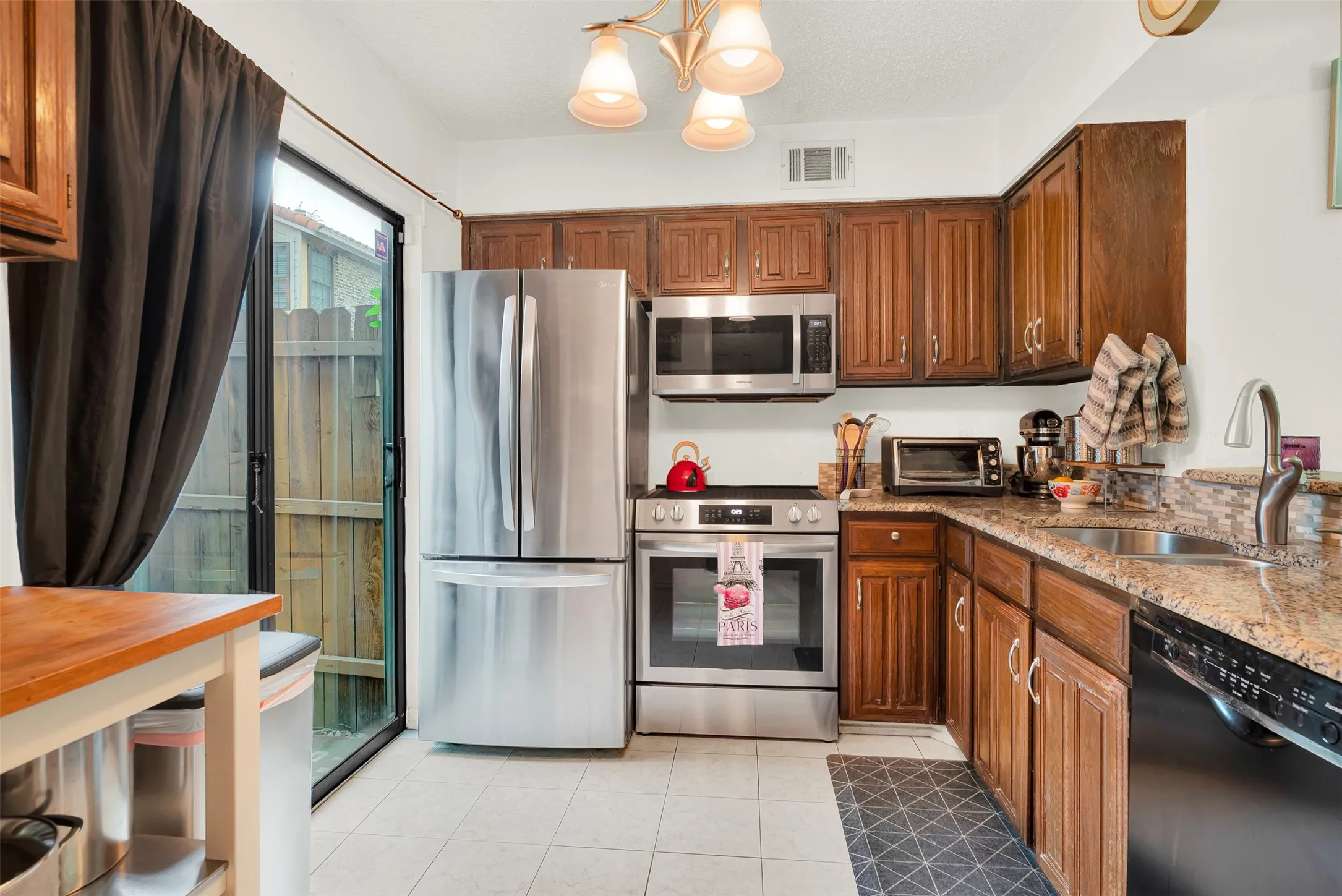 Kitchen featuring wood cabinetry, granite countertops, and a tiled backsplash