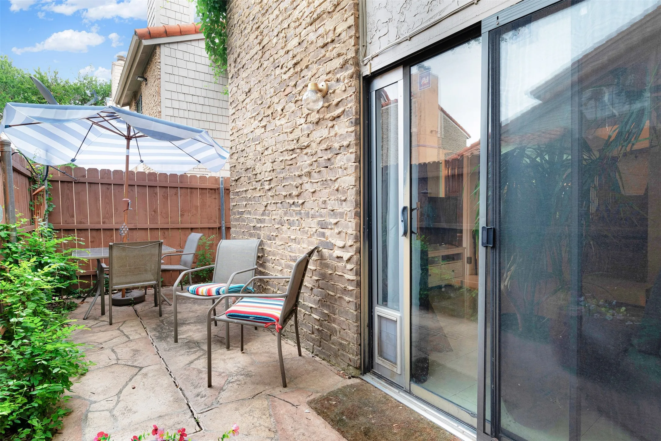Private patio featuring irregular flagstone paving and an adjacent brick exterior wall