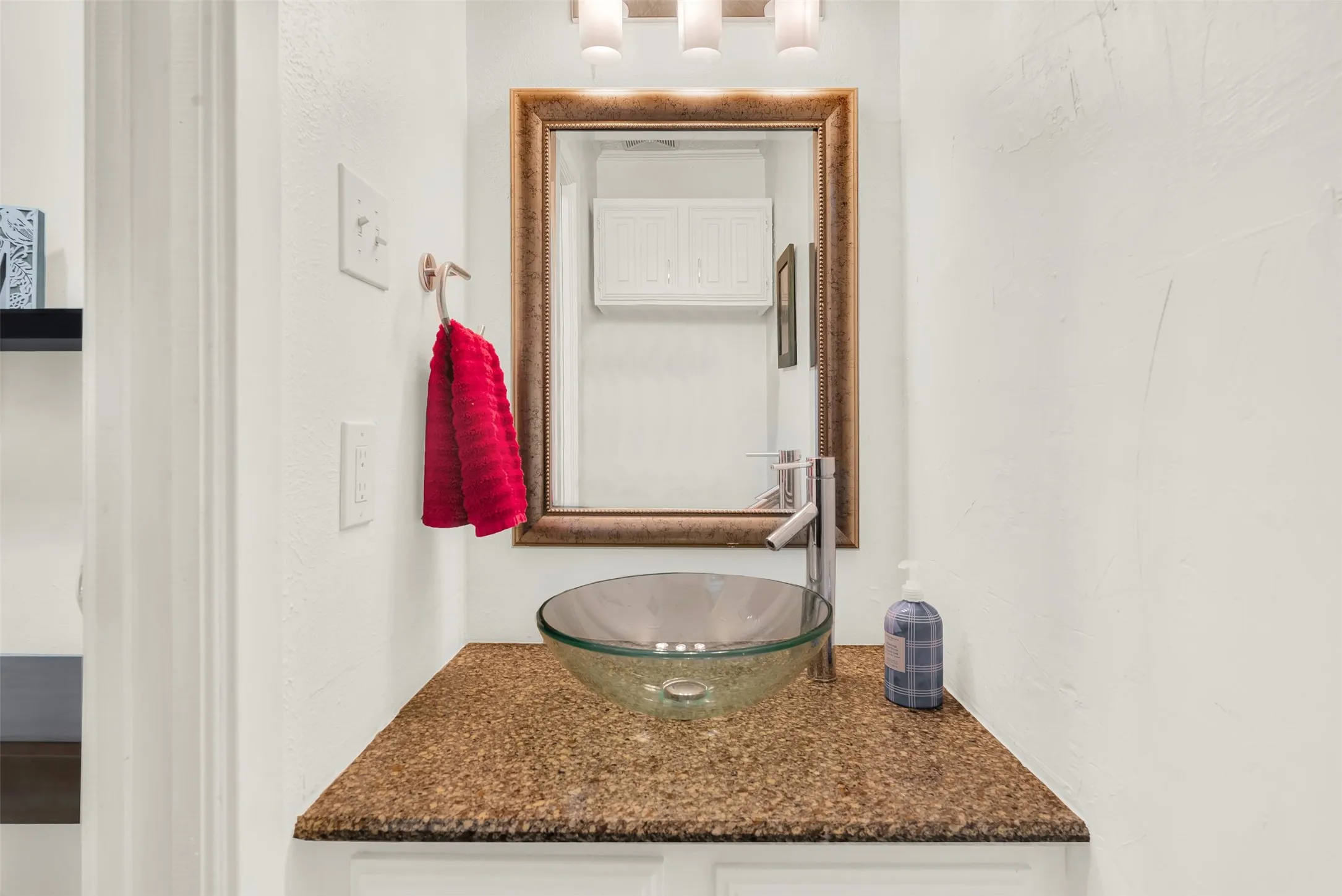  Half bathroom vanity featuring a vessel sink, a tall chrome faucet, and a framed mirror