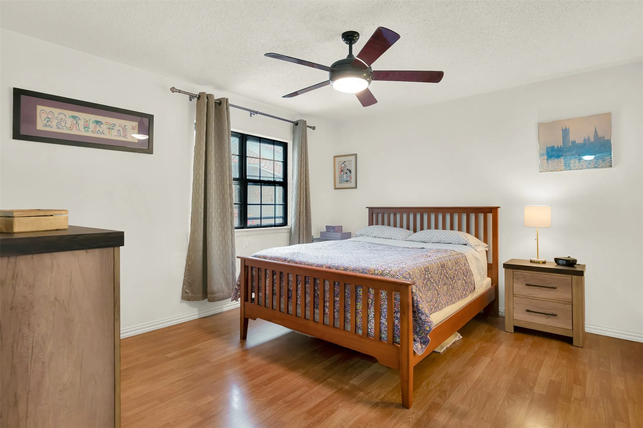 Bedroom featuring wood-finish flooring, a ceiling fan with light fixture, and ceiling fan.