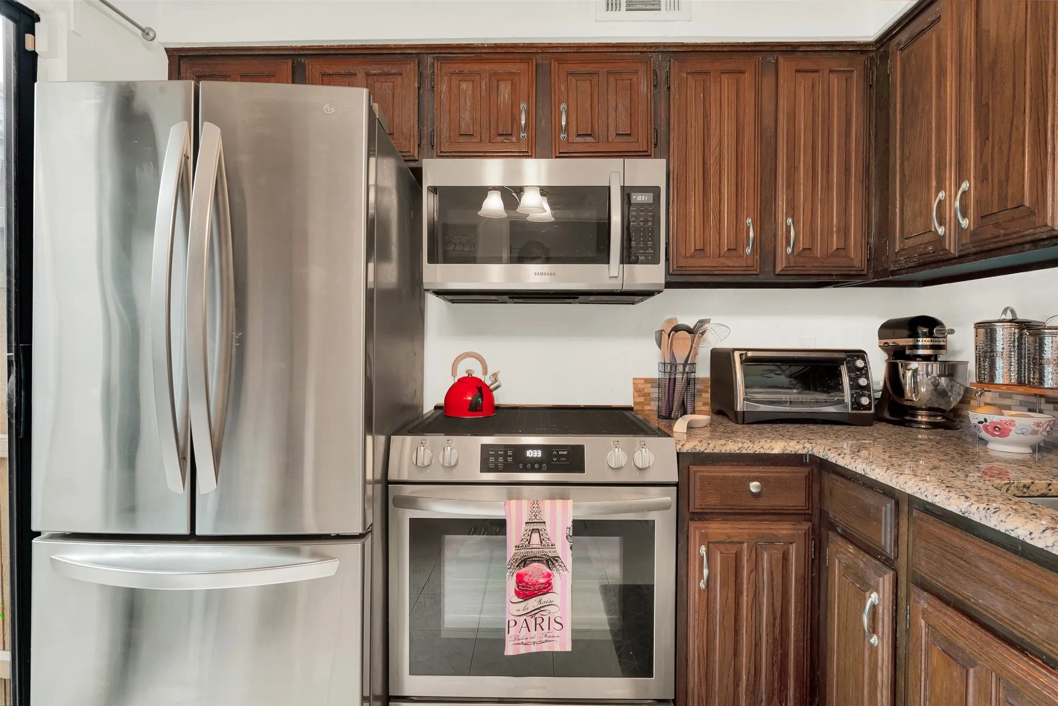 Kitchen featuring stainless steel appliances, including a French door refrigerator, electric range, and microwave