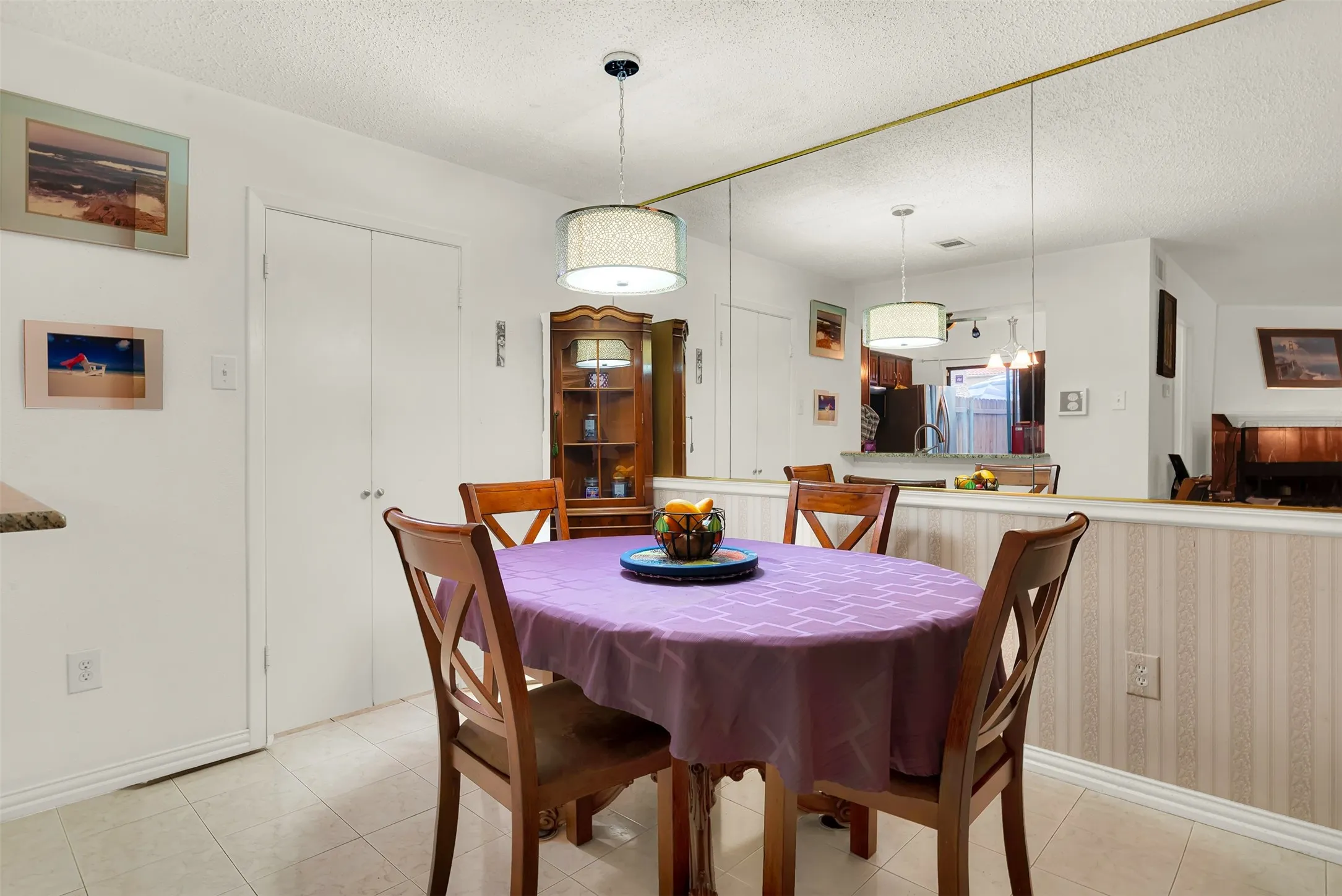 Dining area featuring tile flooring, white walls, and a contemporary drum pendant light​​‌​​​​‌​​‌‌​‌‌​​​‌‌​‌​‌​‌​​​‌​​ fixture