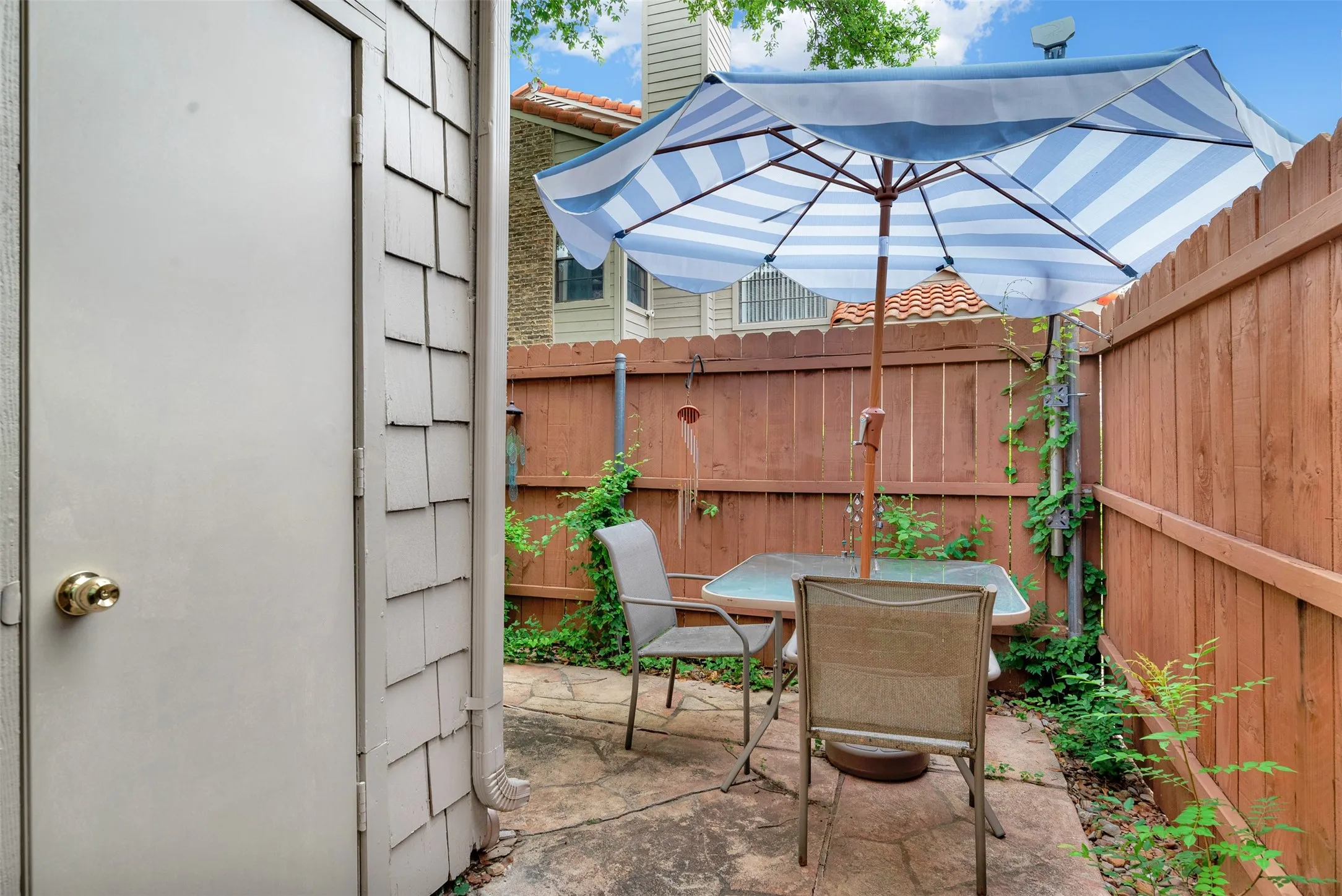 Private patio featuring flagstone paving and a perimeter wood fence