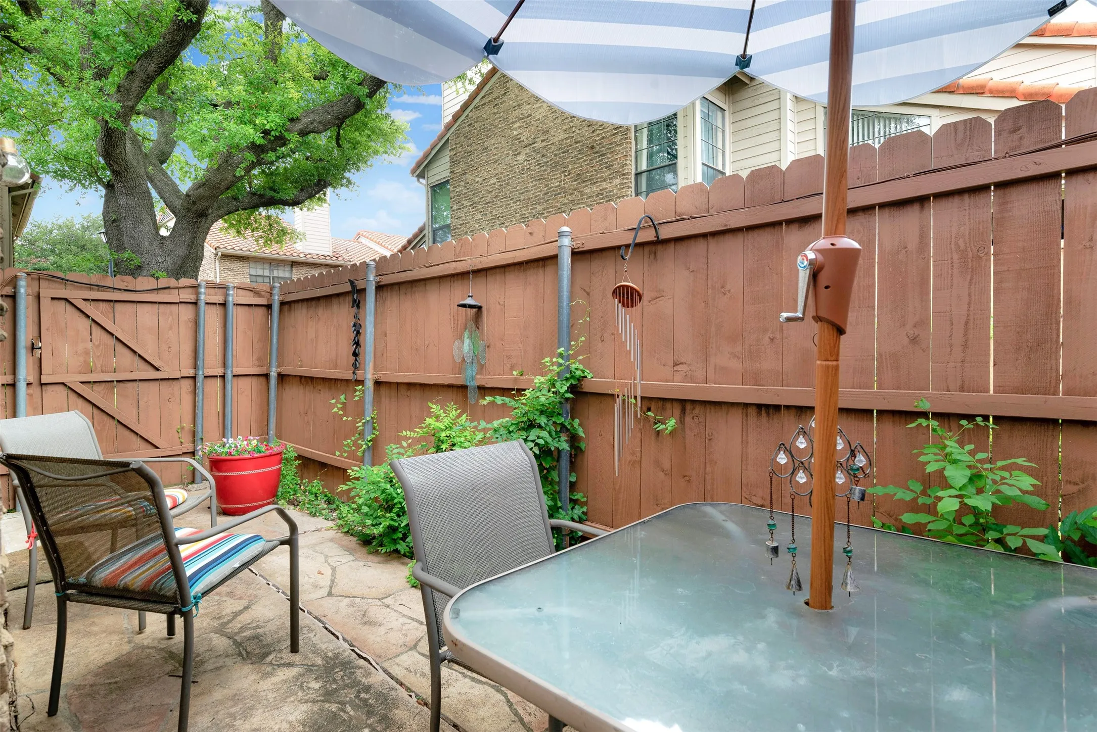 Private patio space featuring a stamped concrete patio, wood privacy fencing, and mature perimeter landscaping