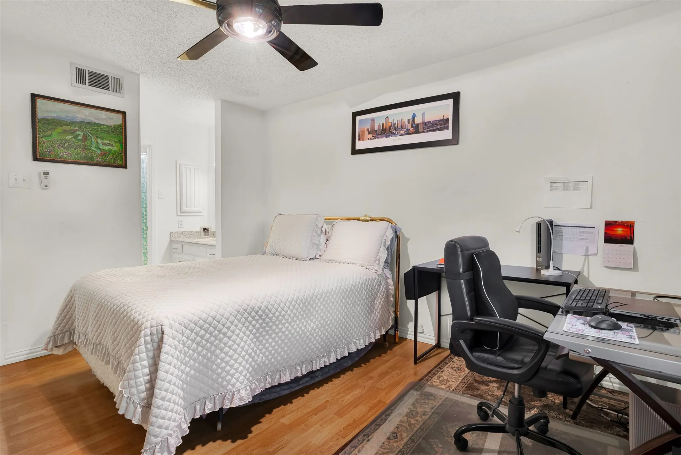 Bright bedroom featuring wood-finish flooring, a ceiling fan with integrated lighting, and white walls