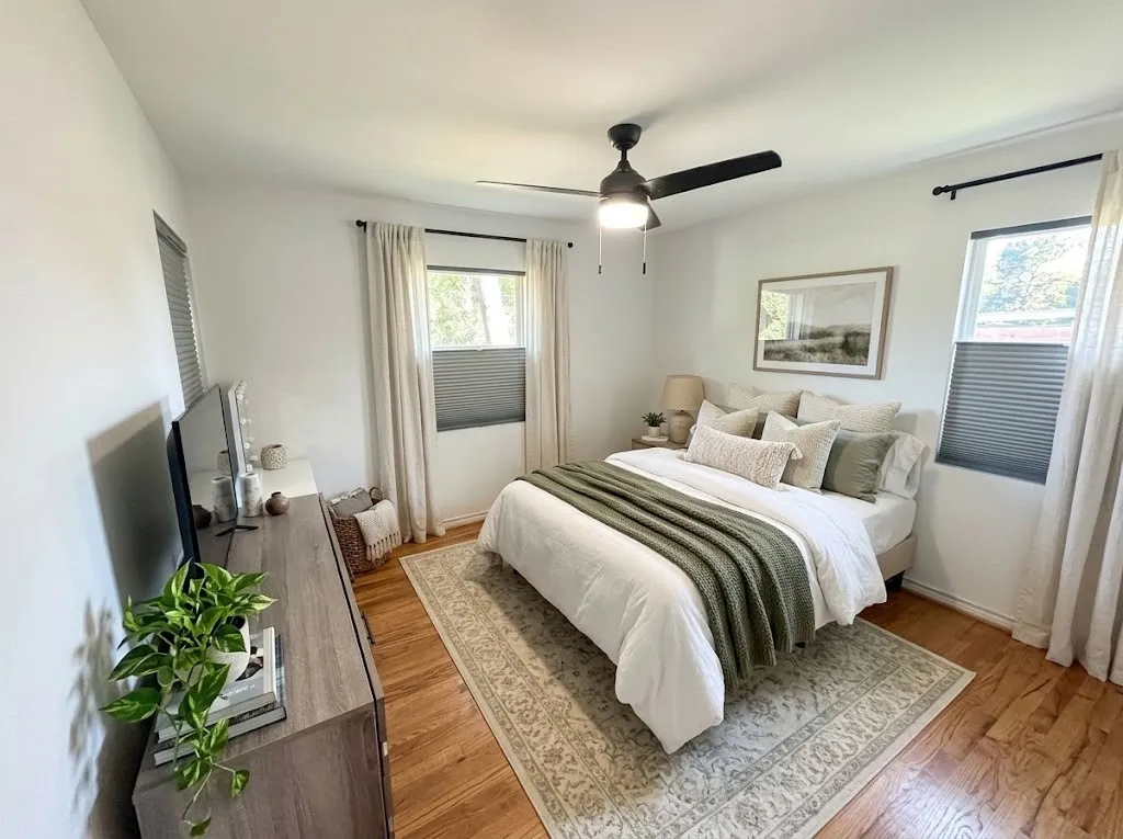 One of three bedrooms, Hardwood flooring, two windows with blinds and curtains, recessed lighting and a ceiling fan with integrated light