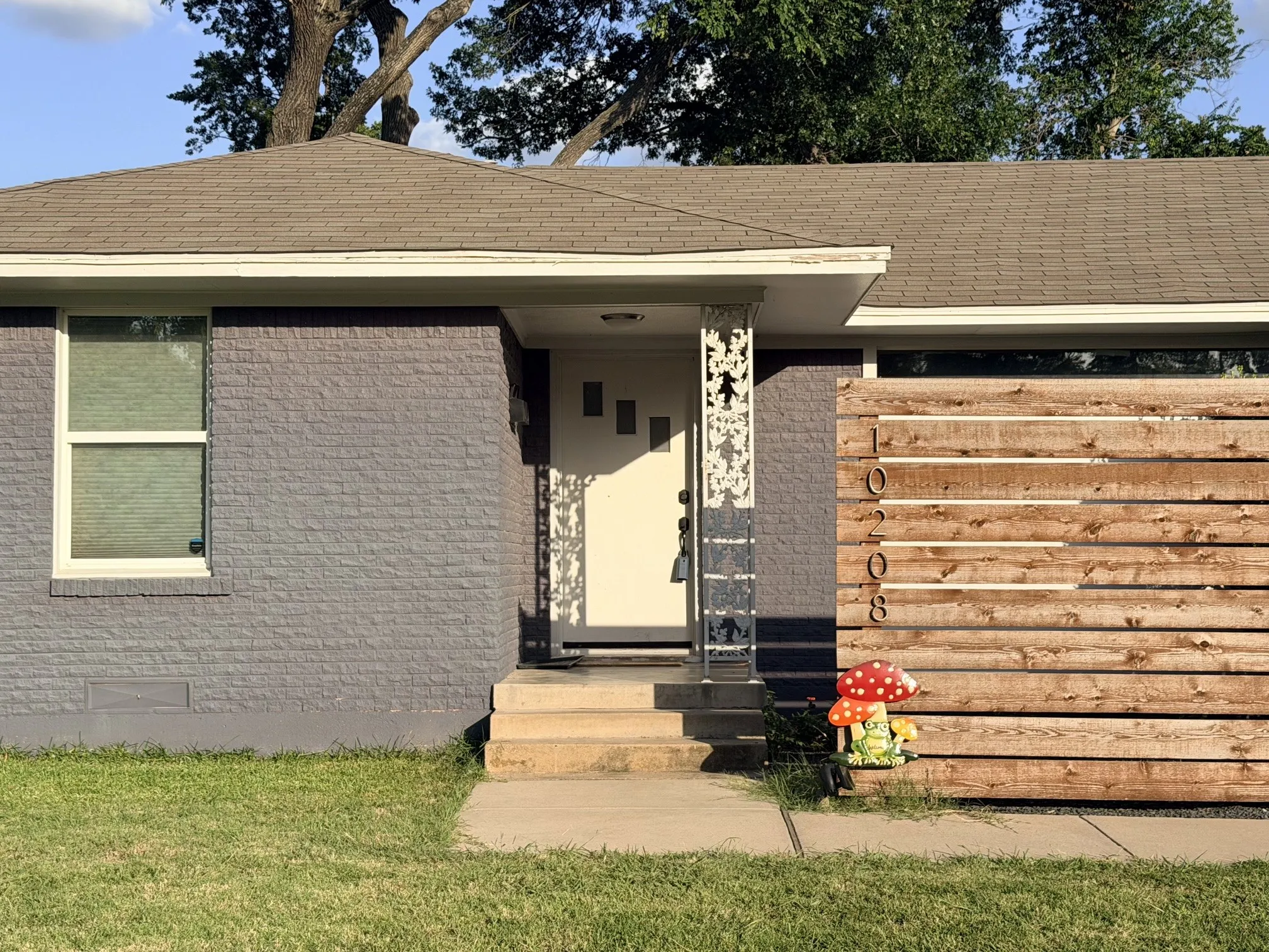 Gray painted brick exterior with a light brown shingle roof
