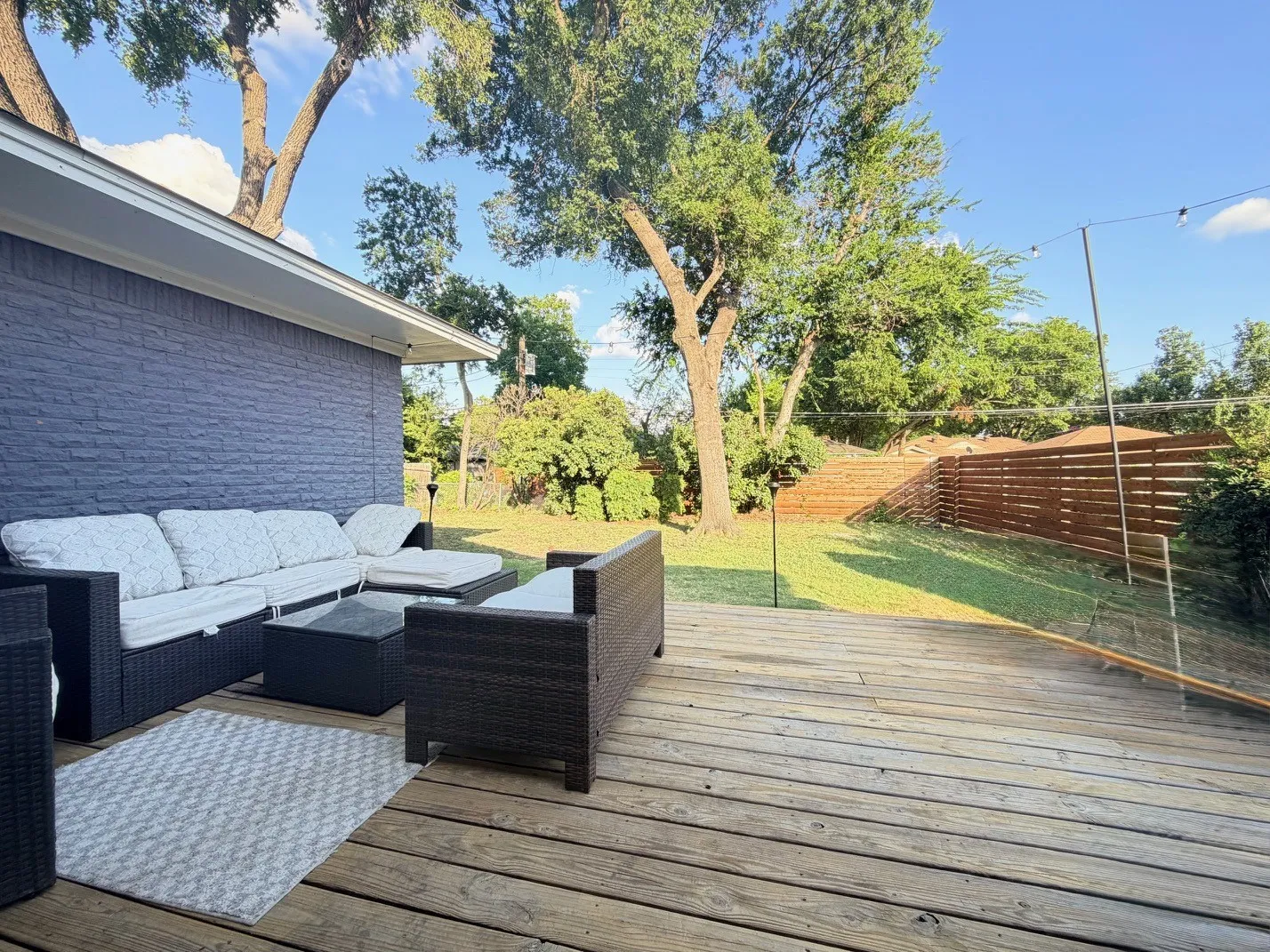 Expansive wood deck with a privacy fence and mature trees