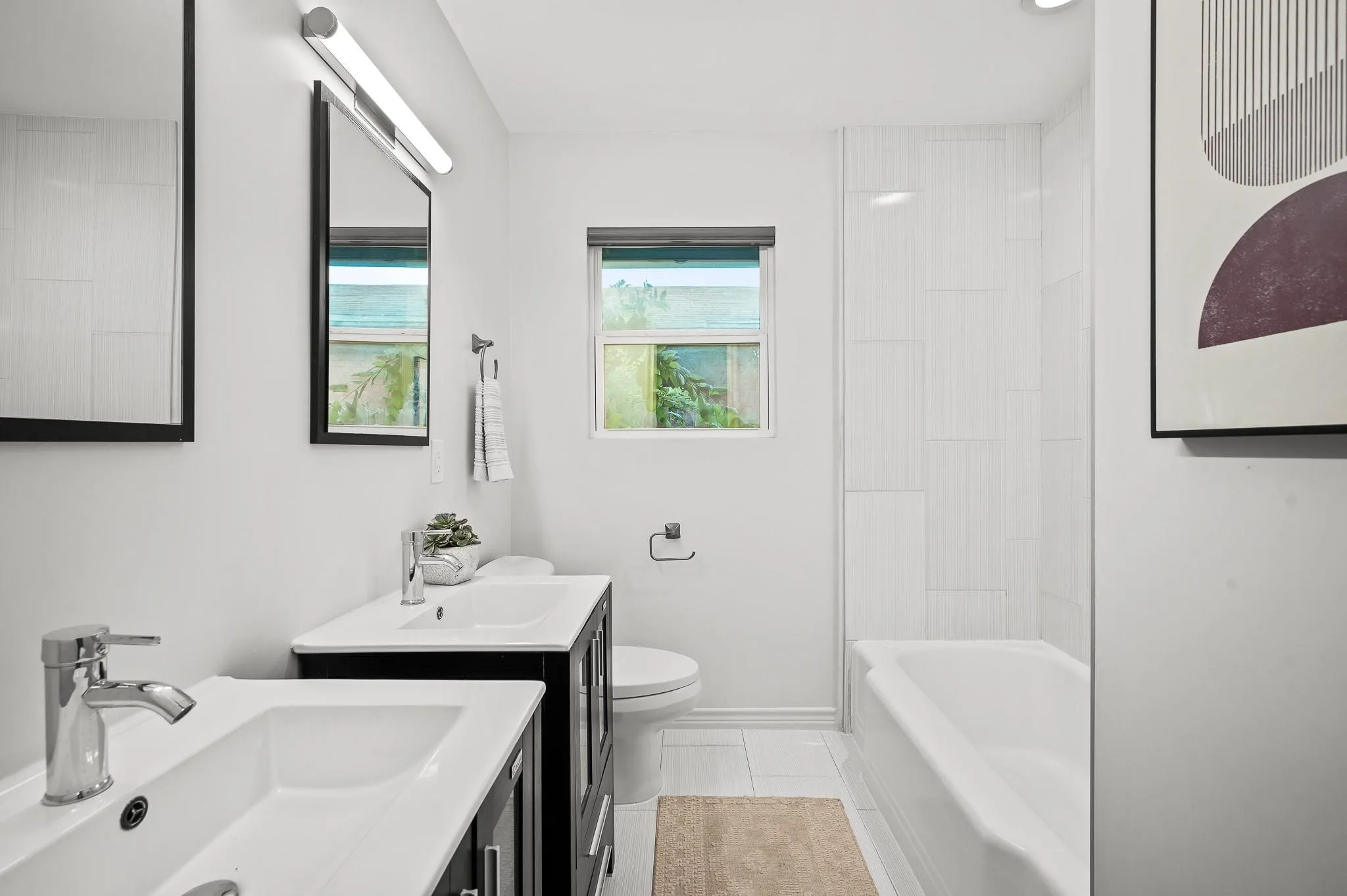 Dual sink vanity with dark wood-finish cabinetry. Vacant older photo.
