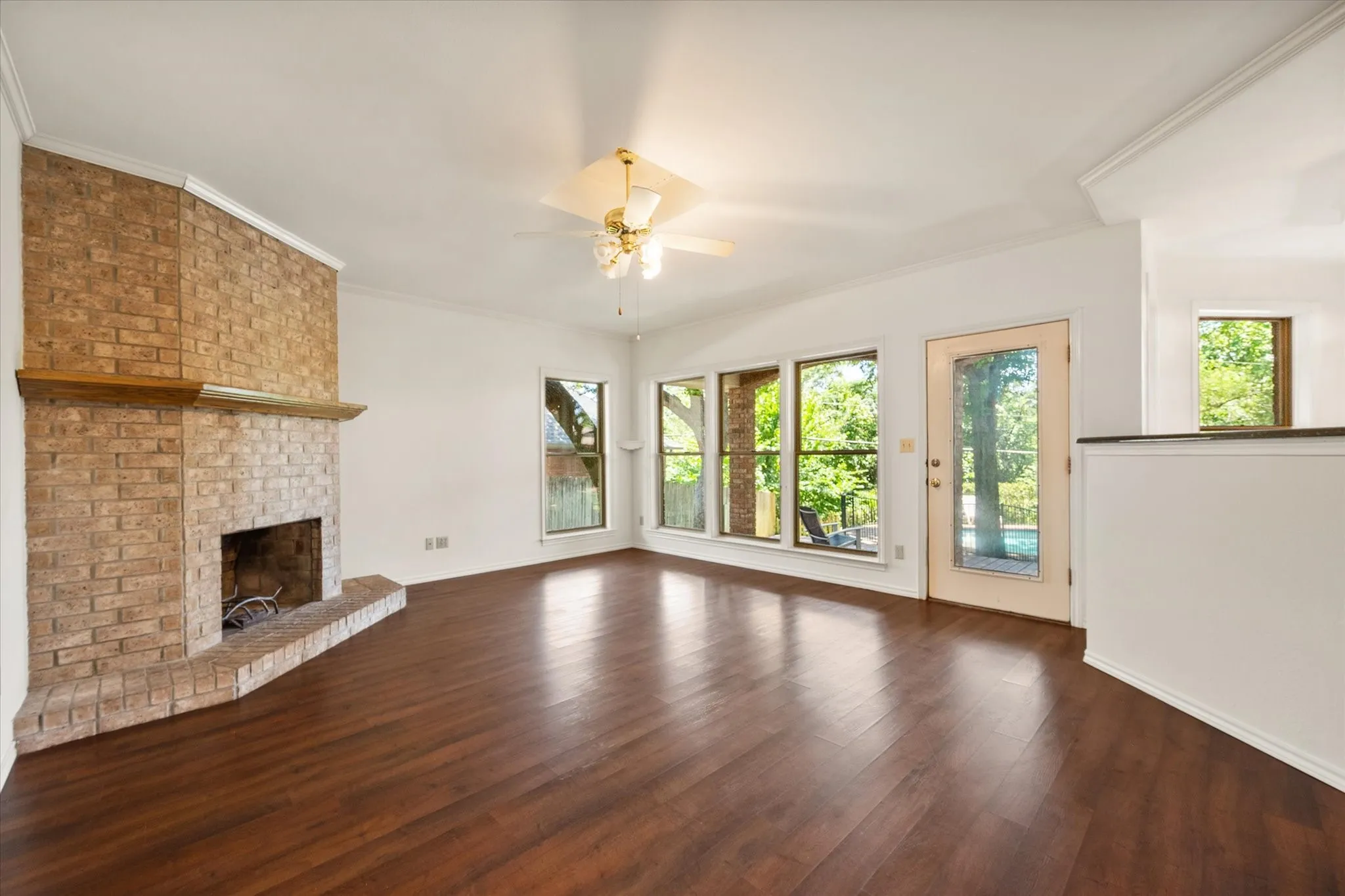 Living room has a wall of windows looking out to the gorgeous backyard with pool