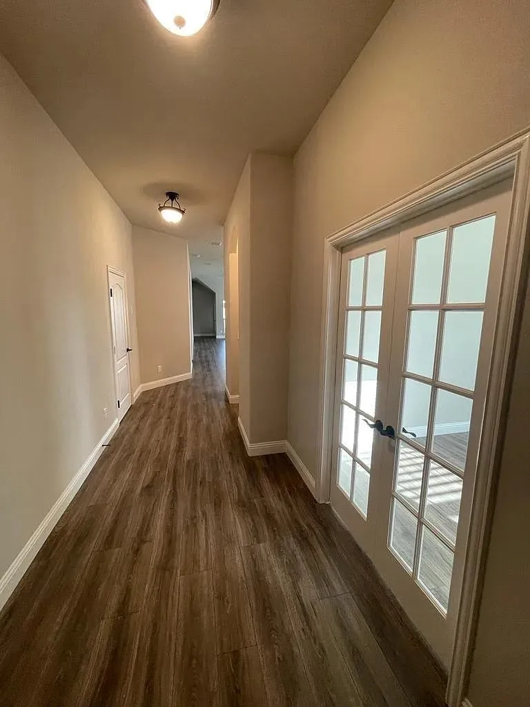 Inviting entryway with wood-finish flooring, neutral wall tones, and white baseboards