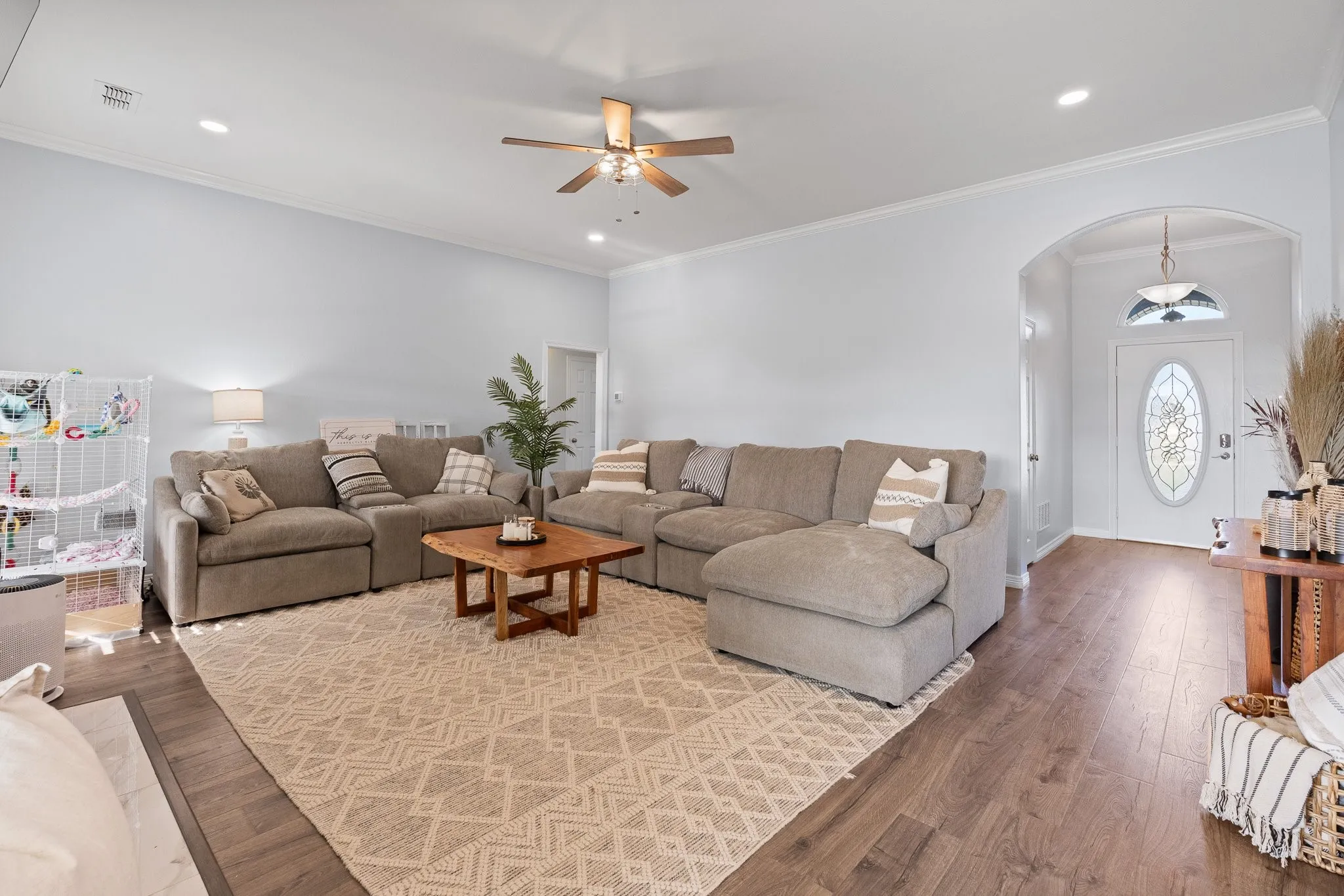 Spacious living area featuring wood-finish flooring, recessed lighting, and a ceiling fan