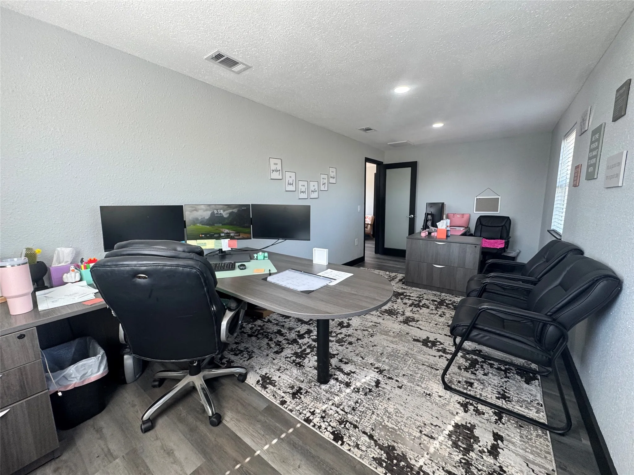 Open-concept office space featuring wood-finish flooring and recessed lighting
