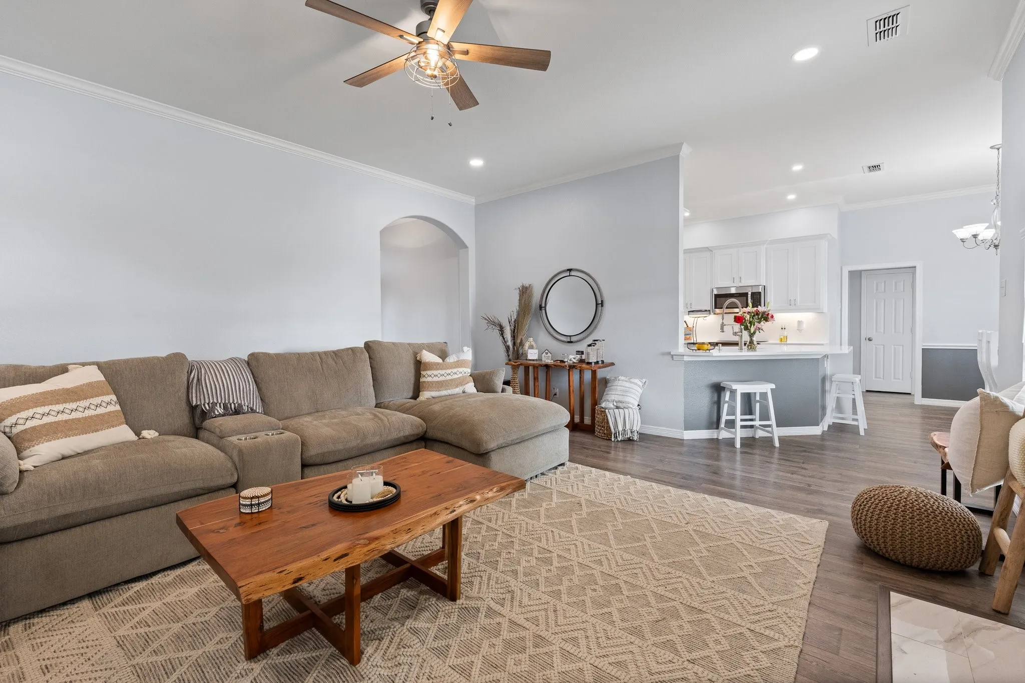 Open-concept living area with wood-finish flooring, recessed lighting, and a ceiling fan
