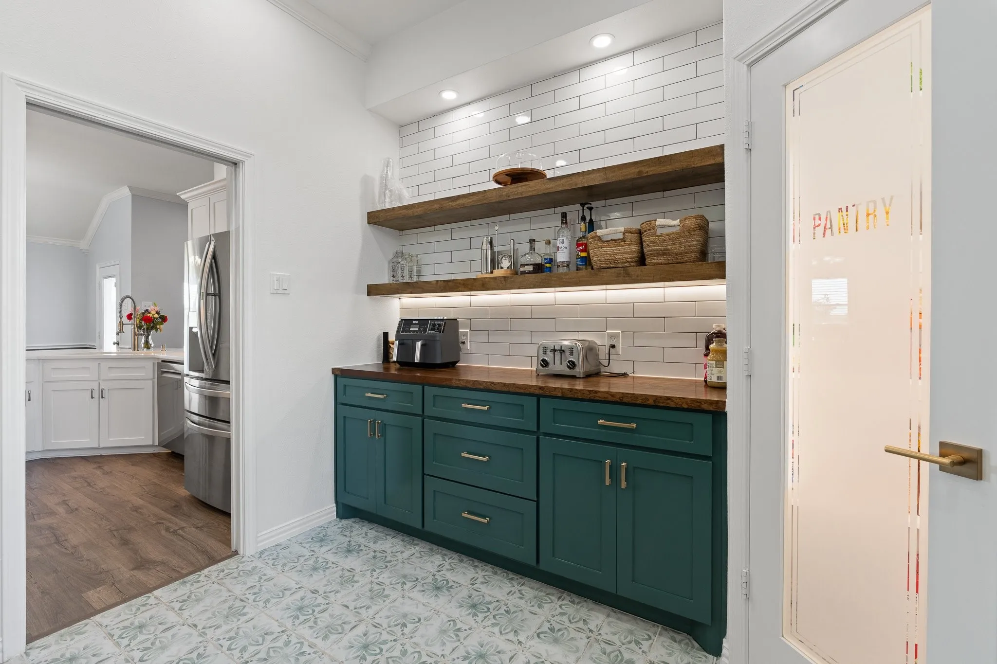 Built-in cabinetry with wood-finish countertop, white subway tile backsplash, and integrated open shelving with under-shelf lighting