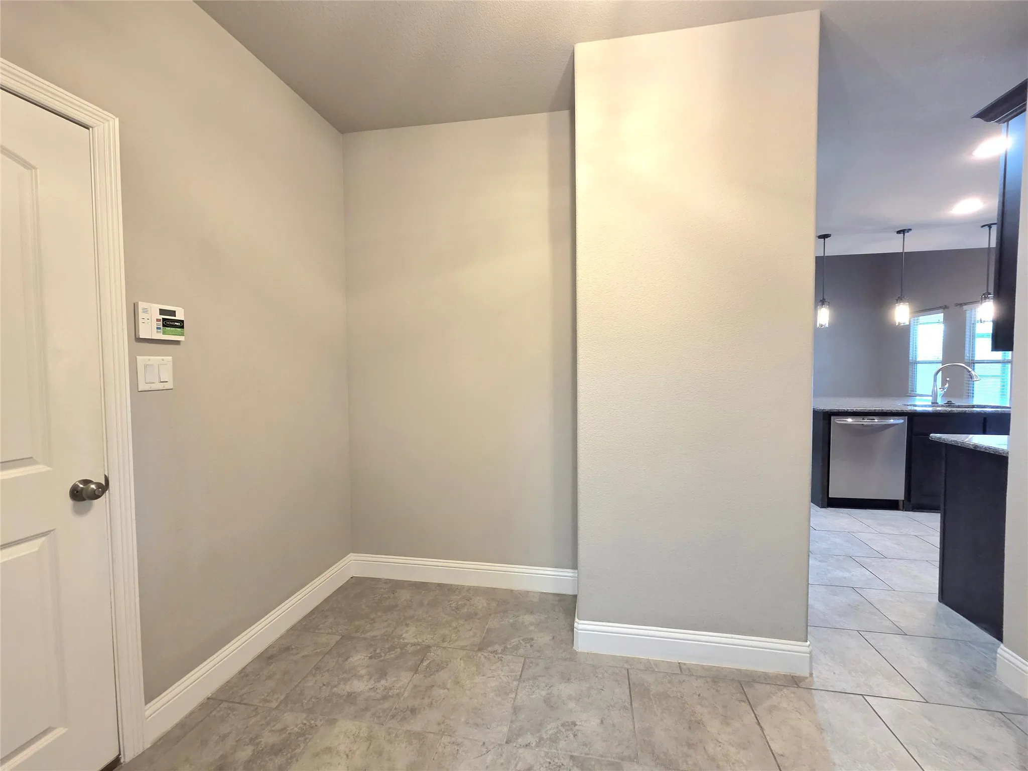 open area, room for a small desk or cabinet off of kitchen-garage entry and laundry room