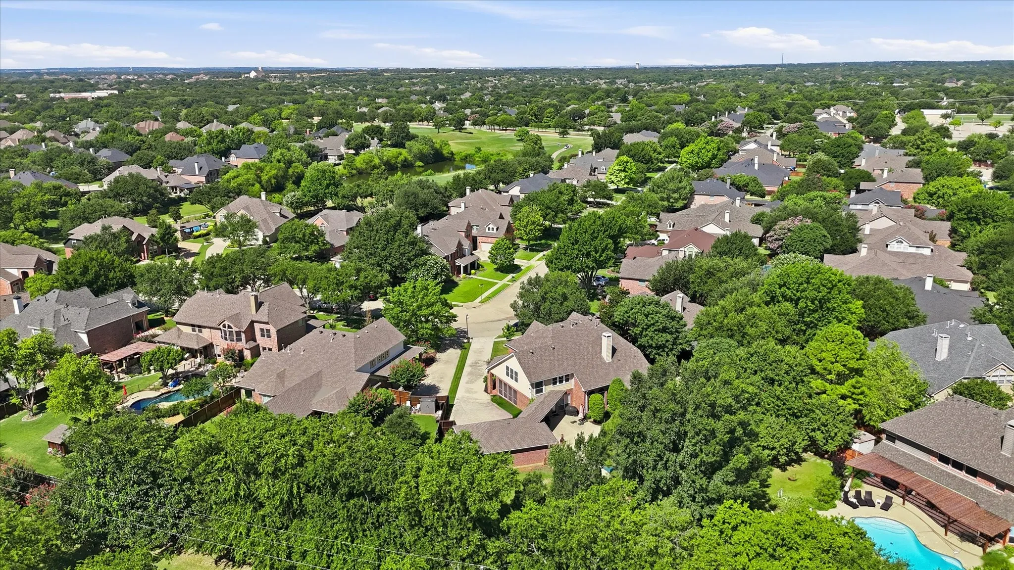 Aerial perspective showcasing a residential community and the property with mature tree coverage
