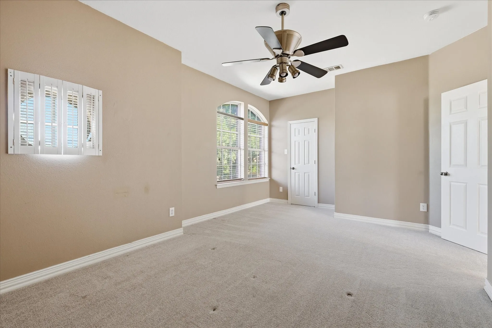 Bedoom featuring neutral-toned walls, light gray carpeting, and a ceiling fan with integrated lighting